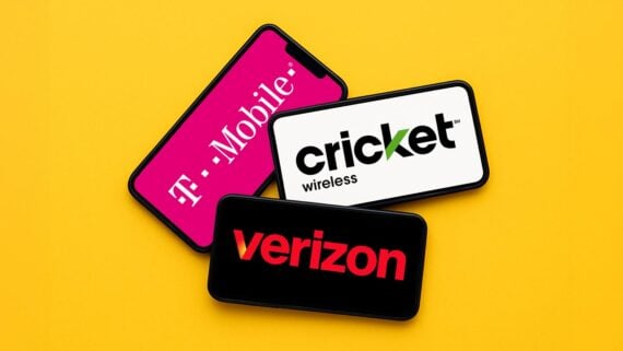 Three smartphones are displayed on a yellow background, each showing a different wireless carrier logo: T-Mobile on a pink screen, Cricket Wireless on a white screen, and Verizon on a black screen.