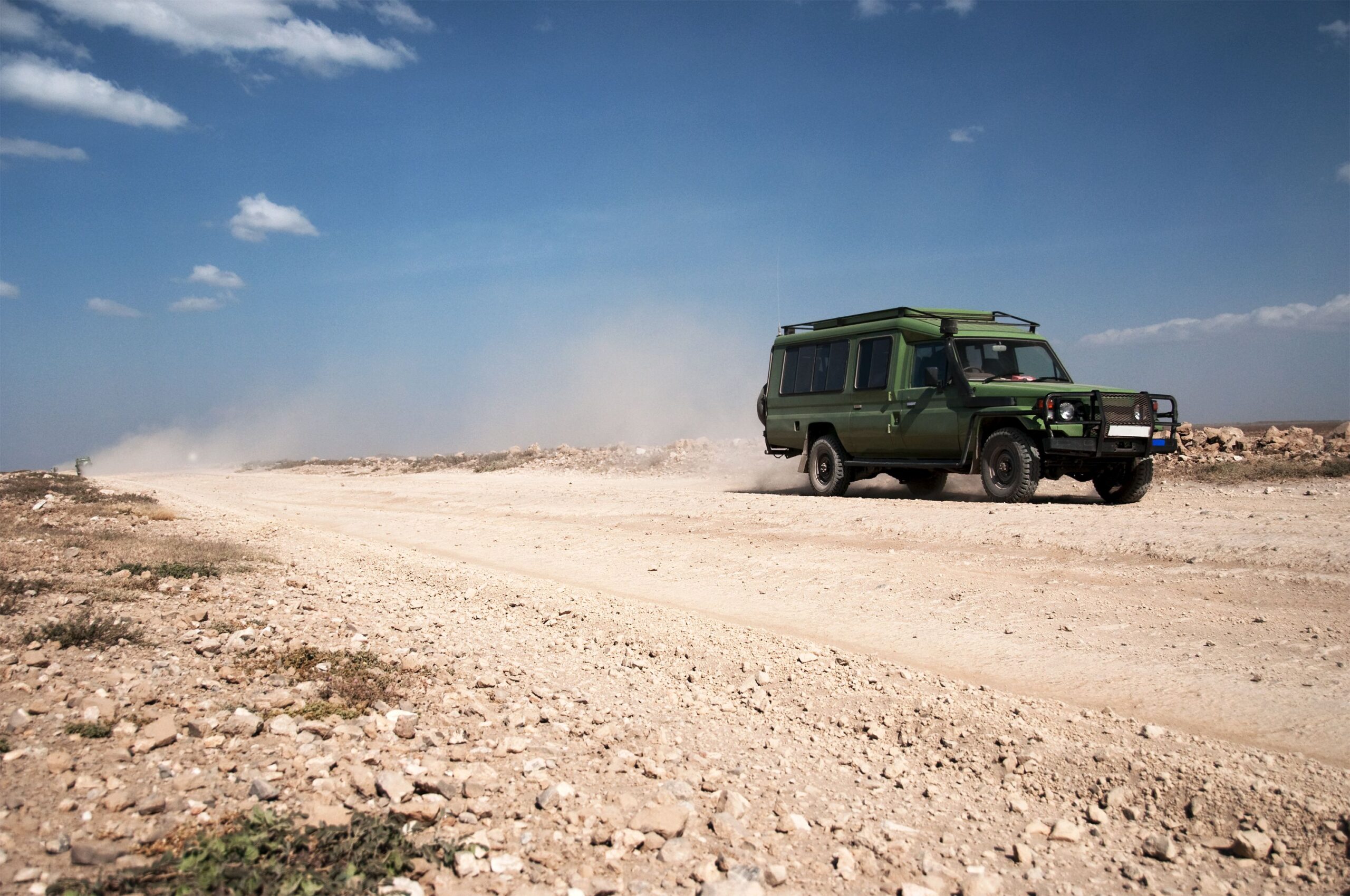 Safari truck on a dirt road. Photo taken in Serengeti, Tanzania.