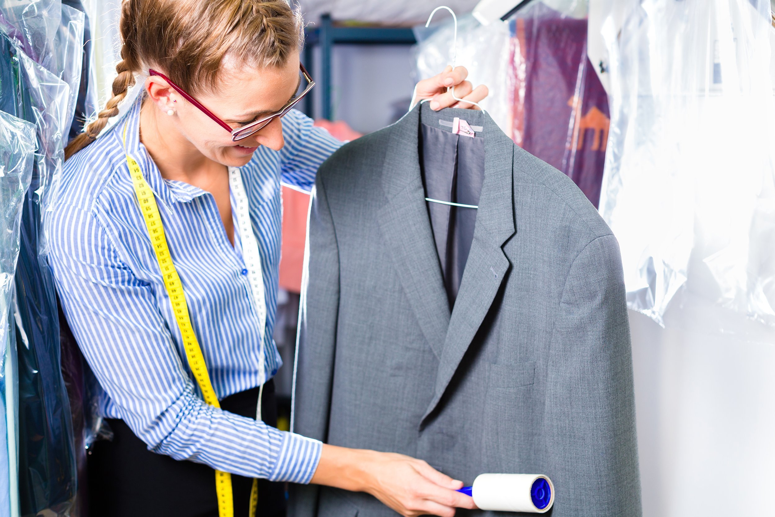 woman in dry cleaner checking clean clothes
