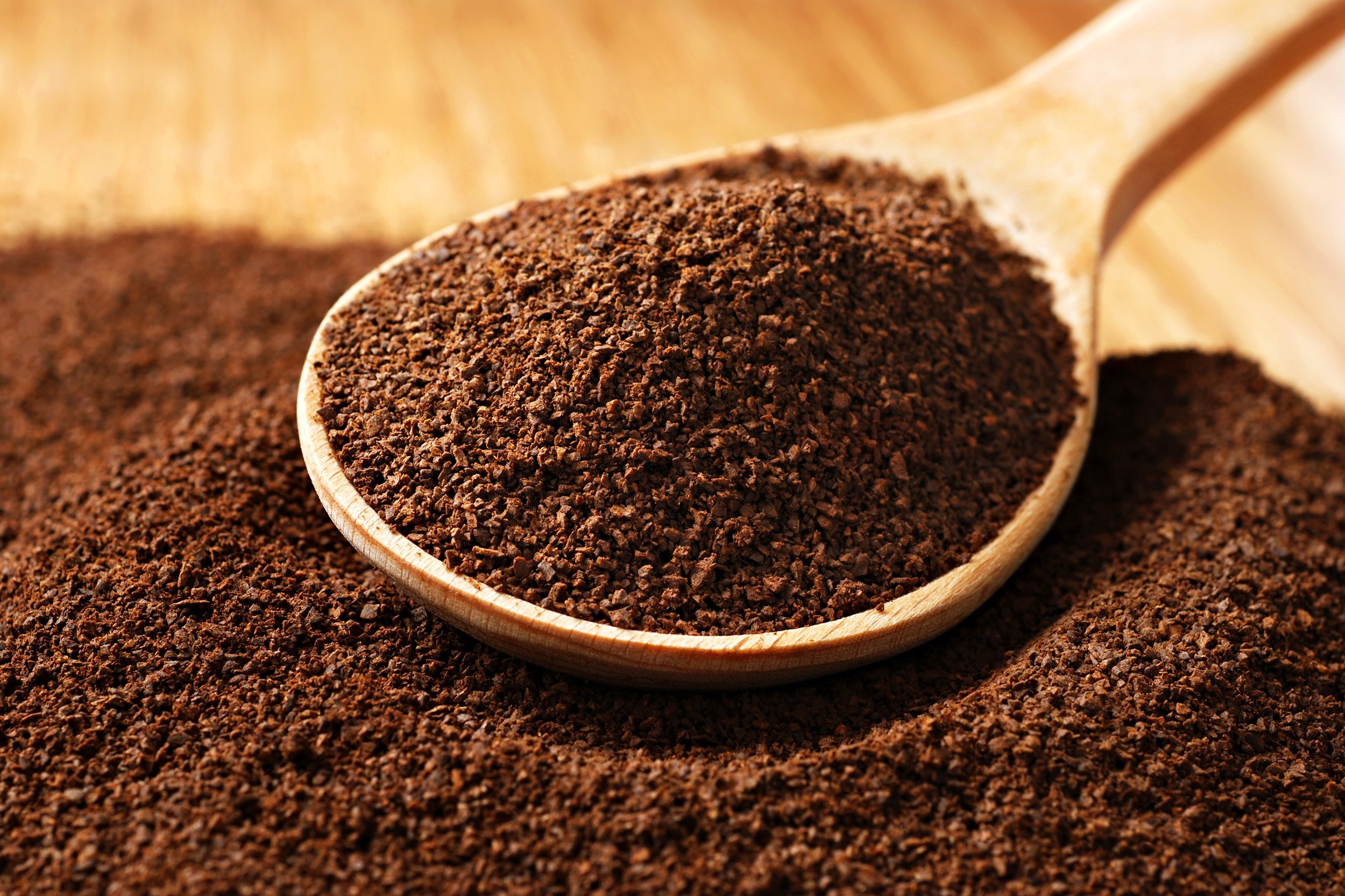 fresh ground coffee with wooden spoon