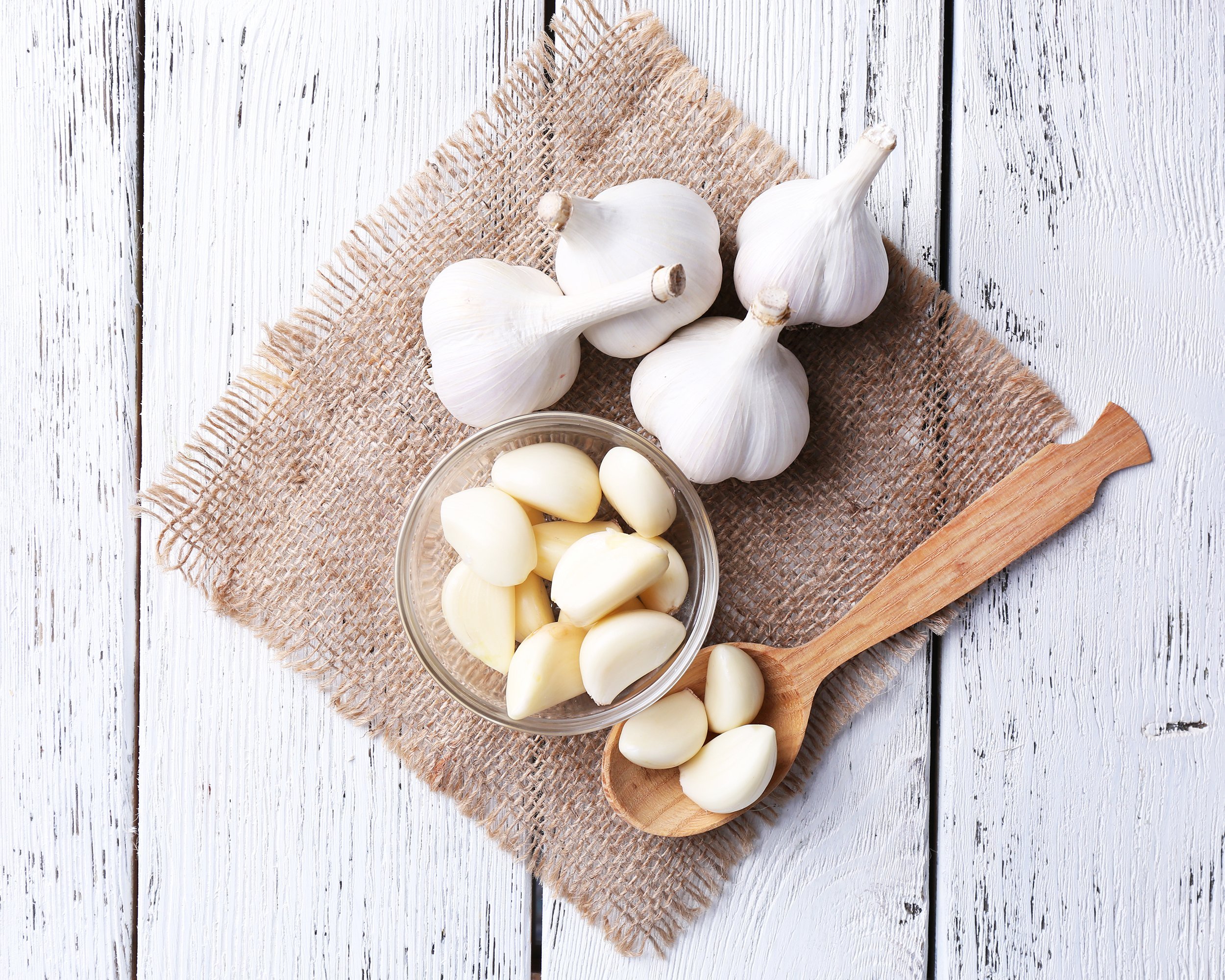 fresh sliced garlic in glass bowl on wooden background
