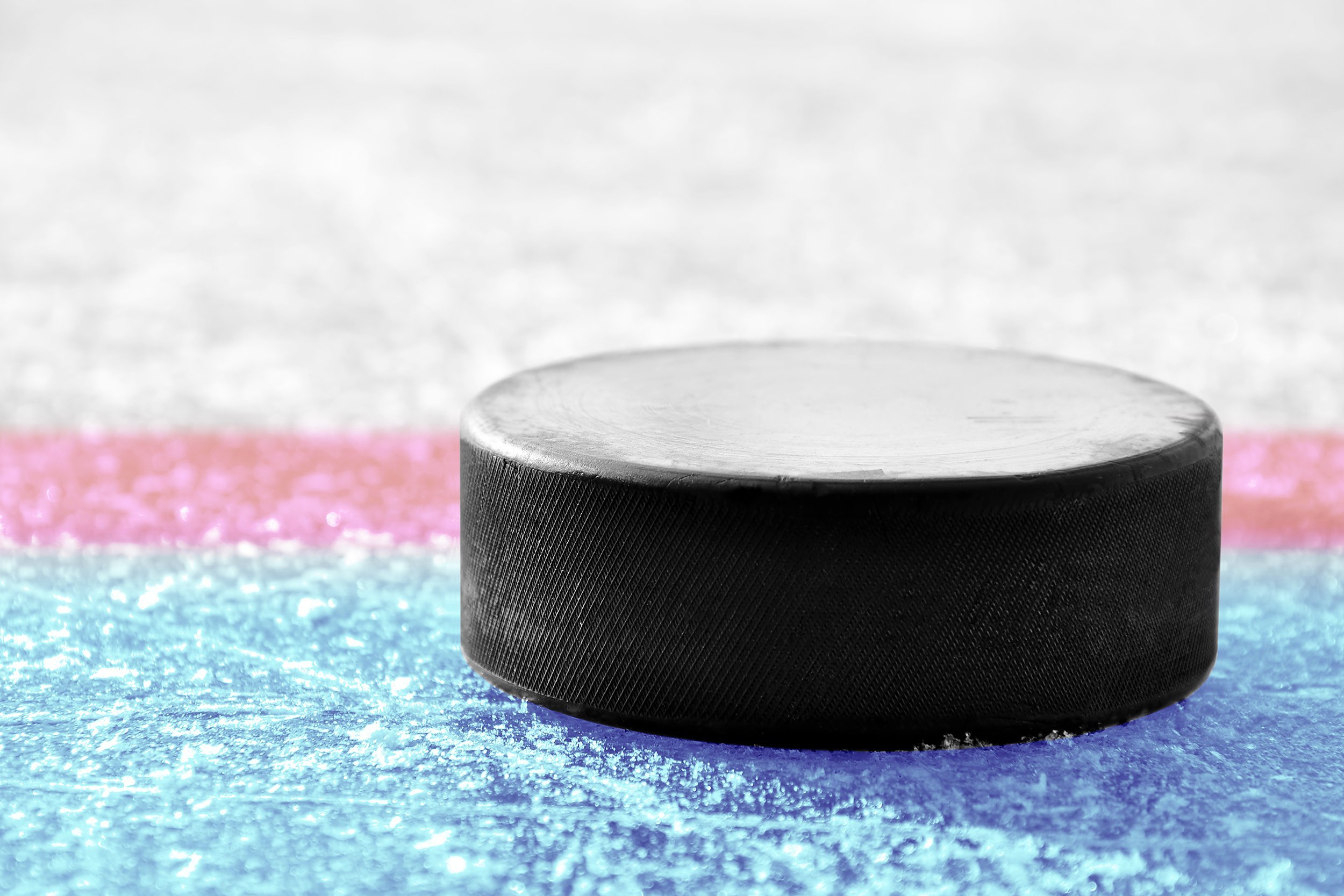 black hockey puck on ice rink