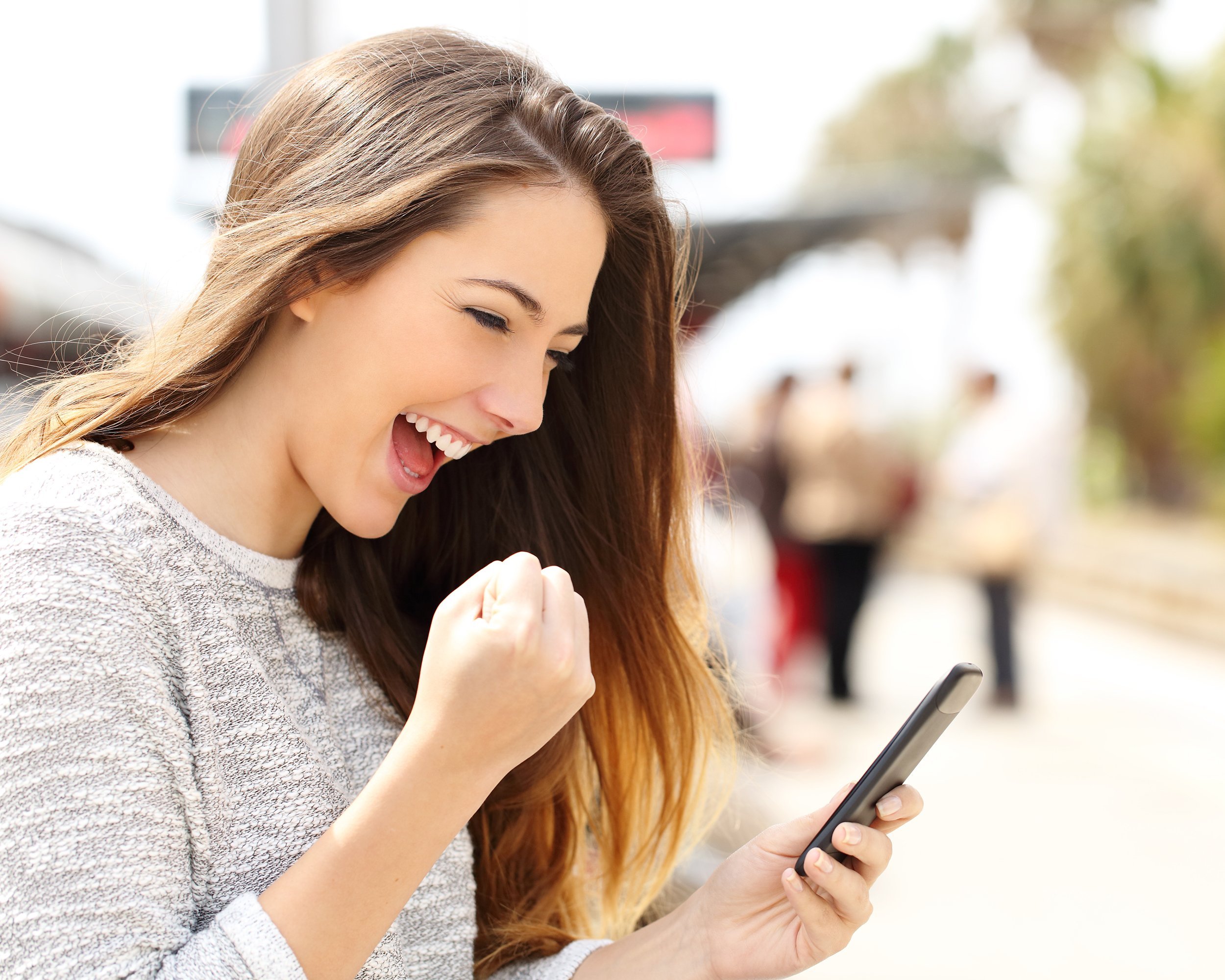 euphoric woman watching her smart phone