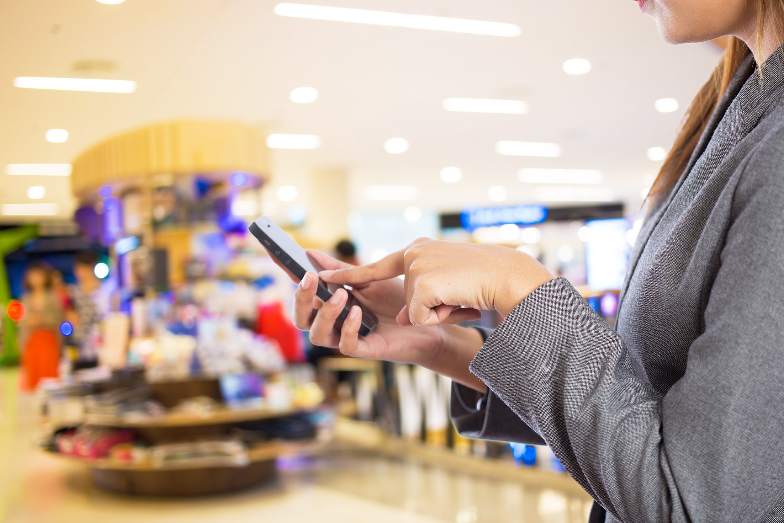 women in shopping mall using mobile phone