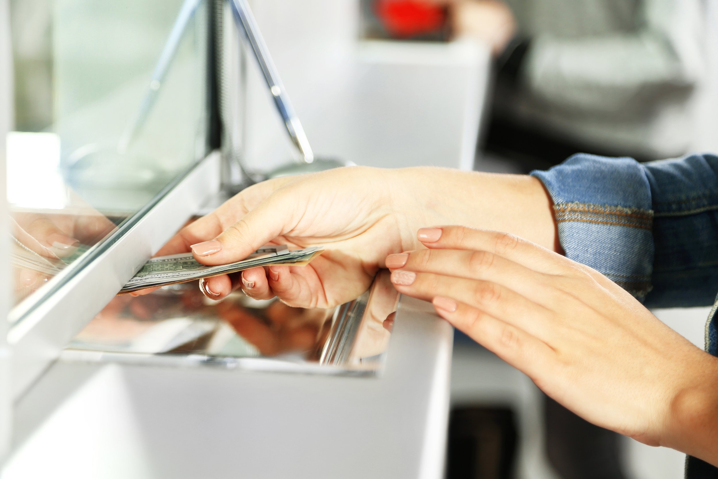 female hand with money in cash department window