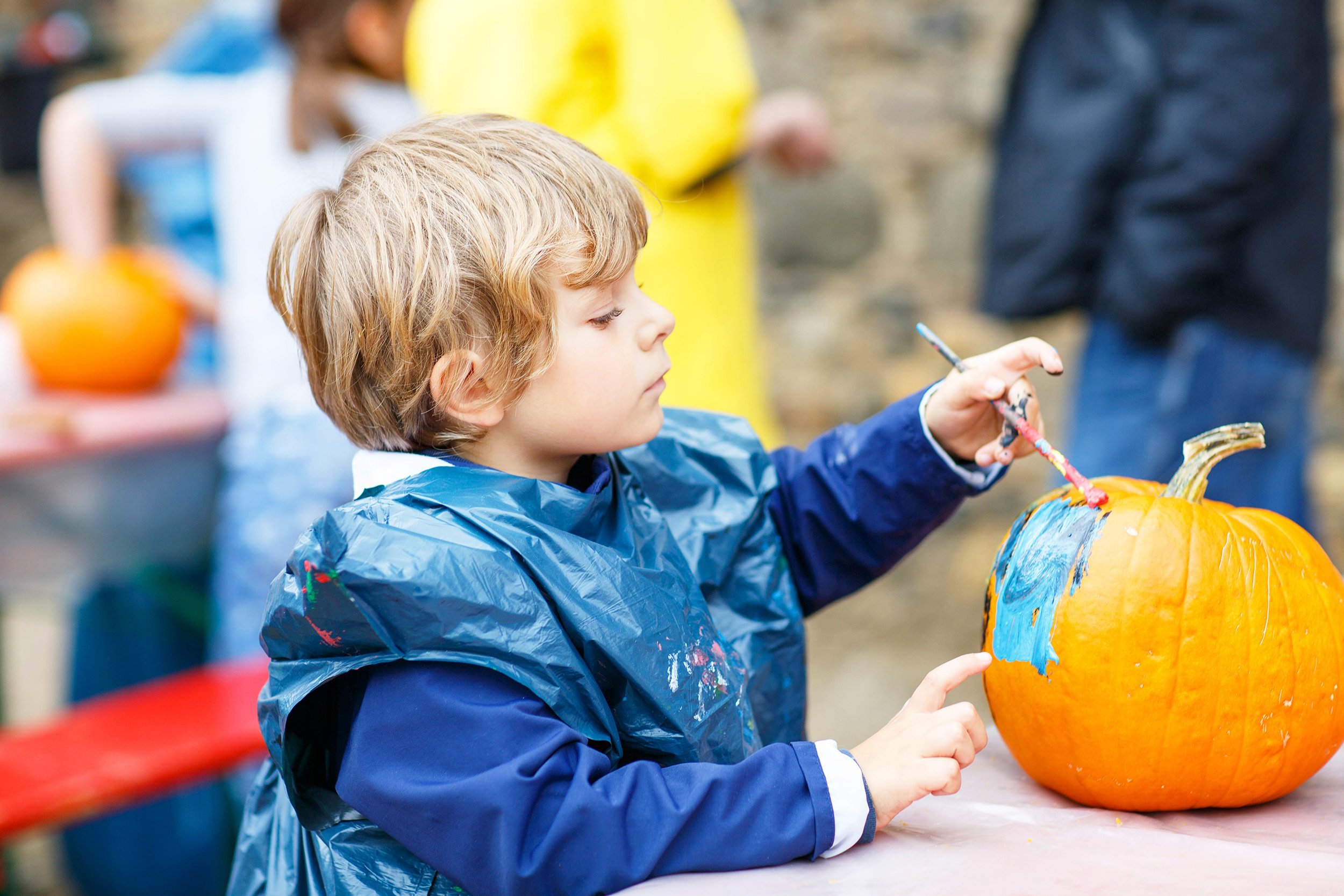 child painting pumpkin at festival