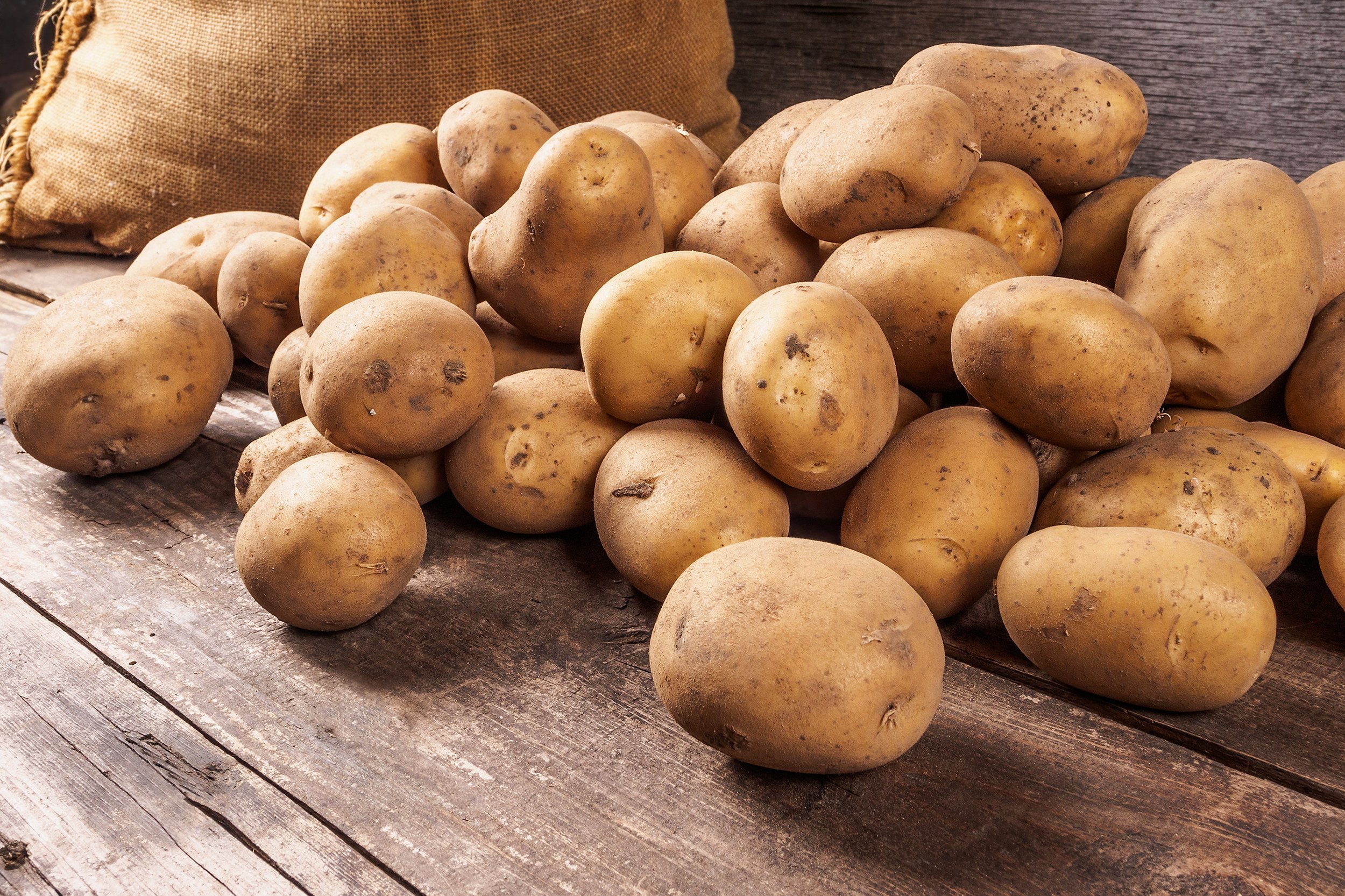 pile of potatoes lying on wooden board