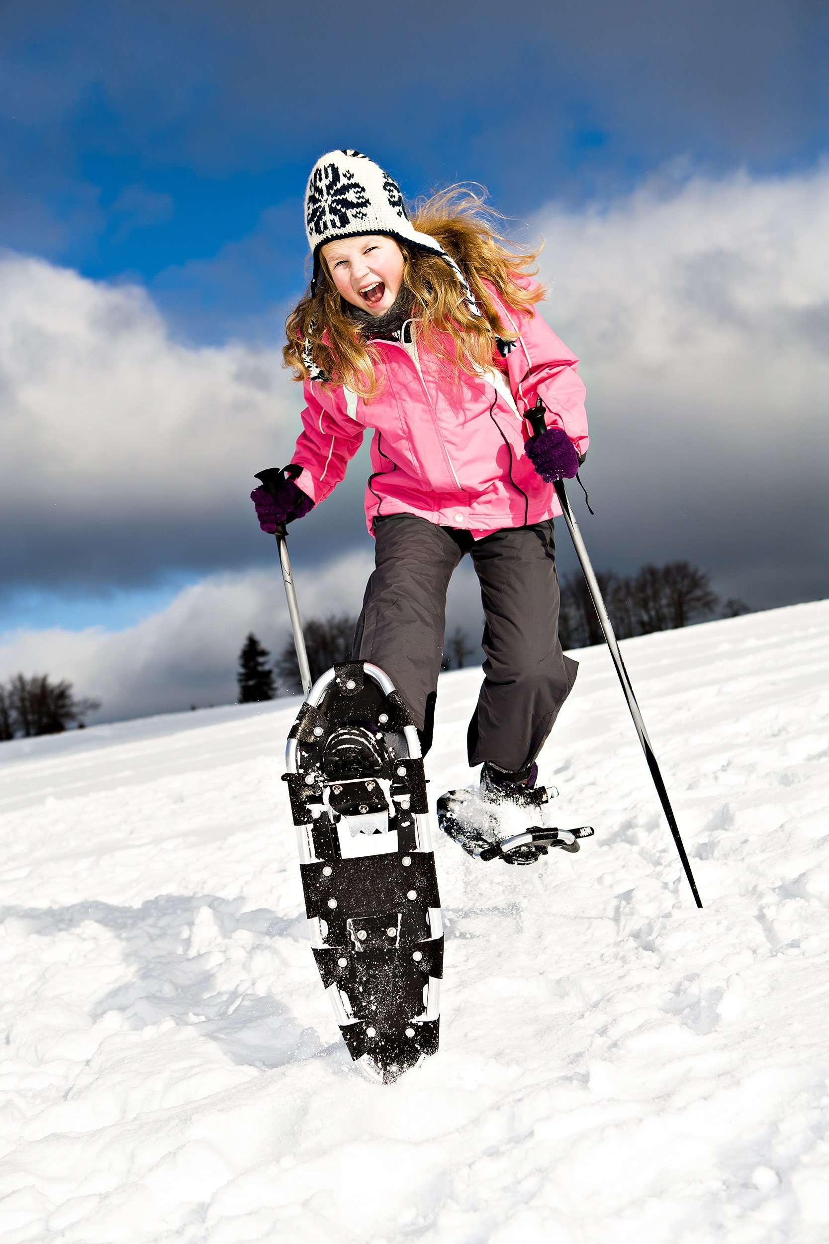 young girl running with snowshoes