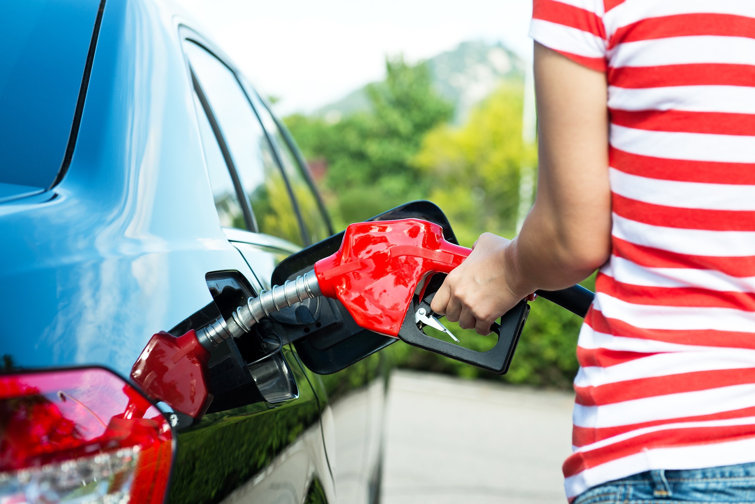 hand refilling the car with fuel