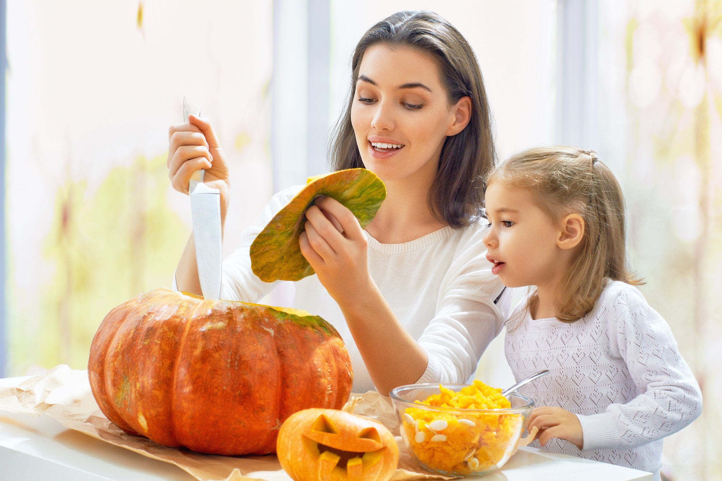 mother and daughter carving pumpkin