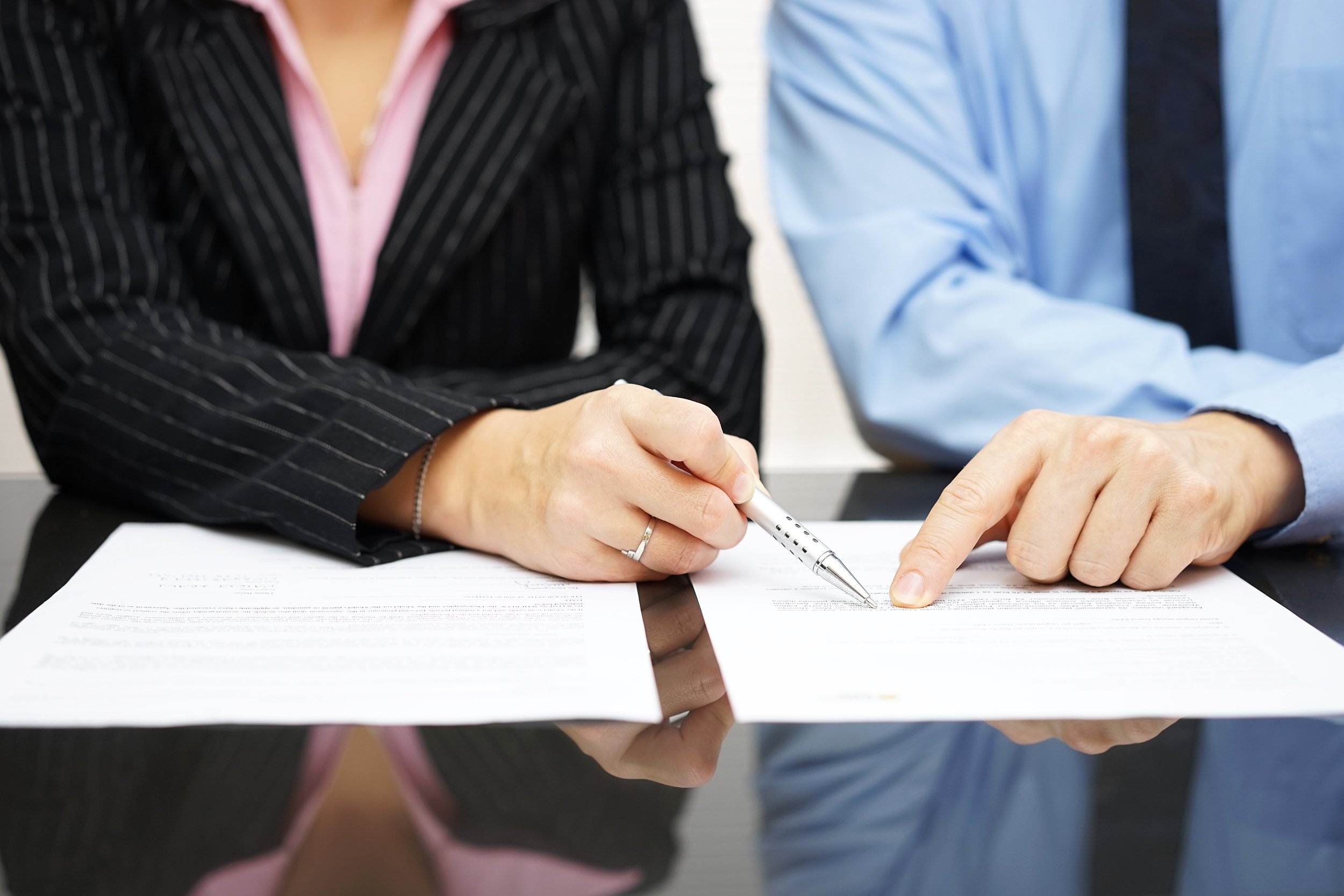 businessman and businesswoman are pointing to article of the treaty