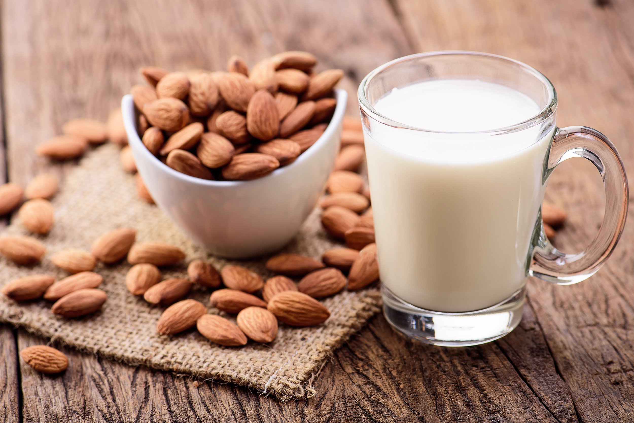 almond milk in glass with almonds