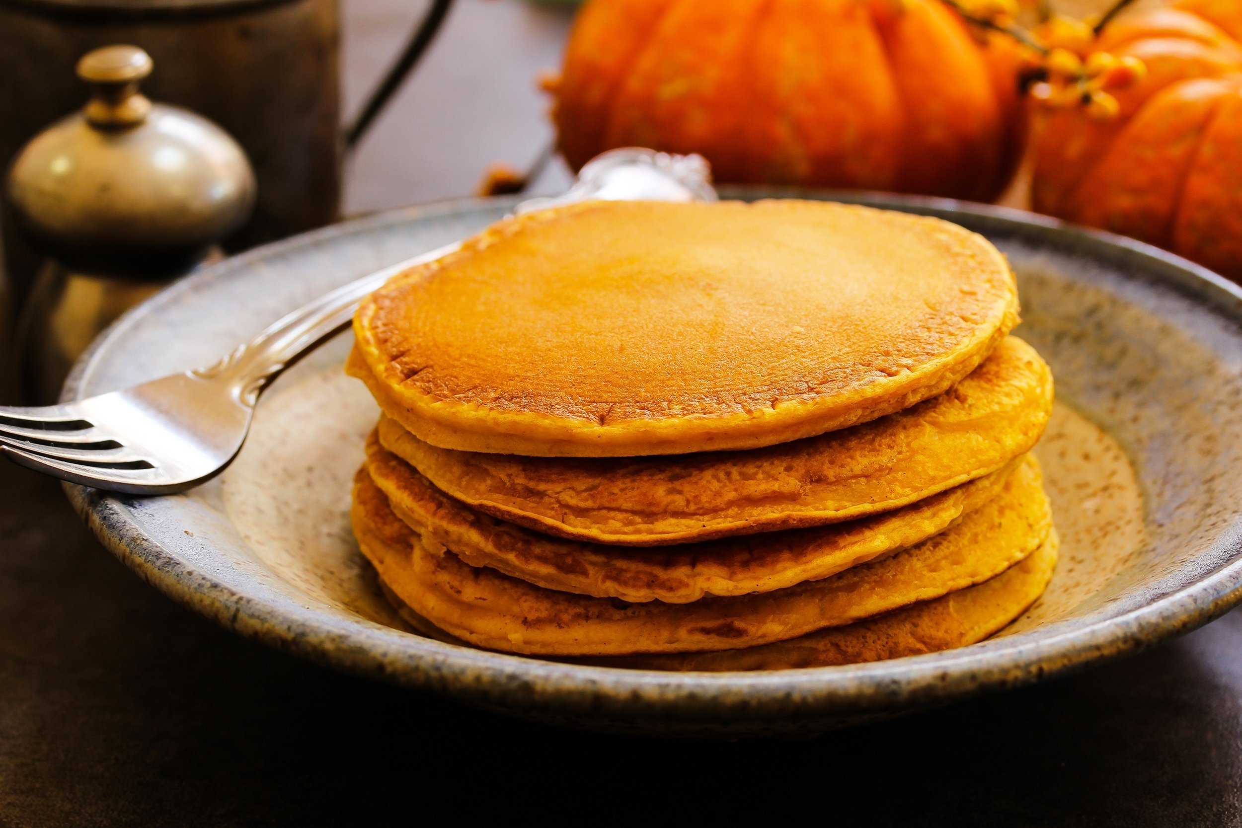 stack of homemade pumpkin pancakes with fall background