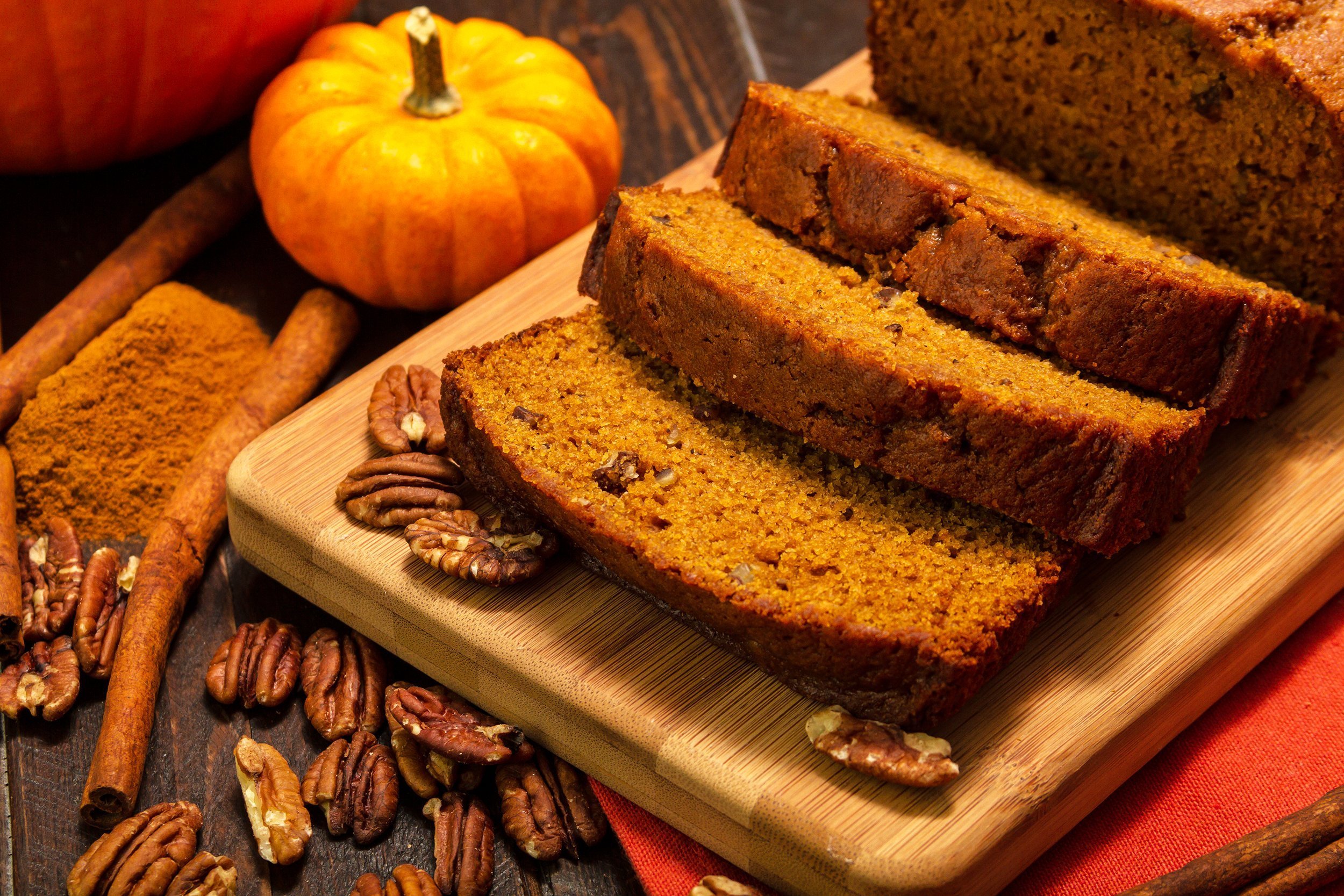 pumpkin bread loaf sitting on wooden cutting board