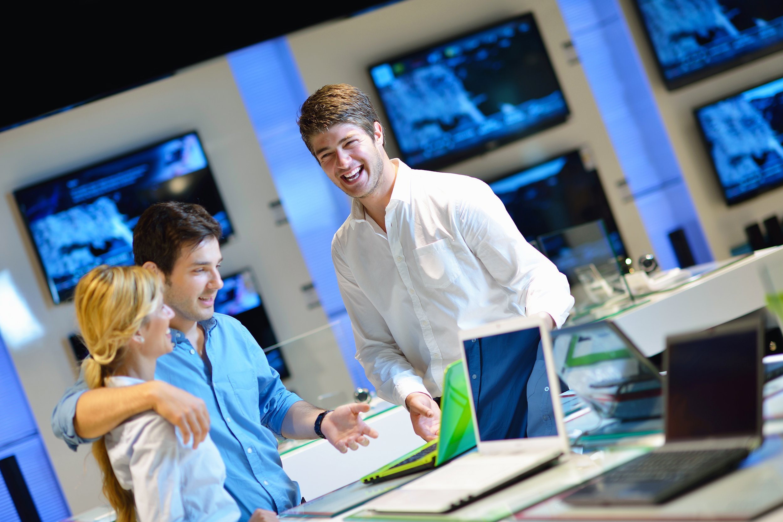 couple in consumer electronics store looking at laptop