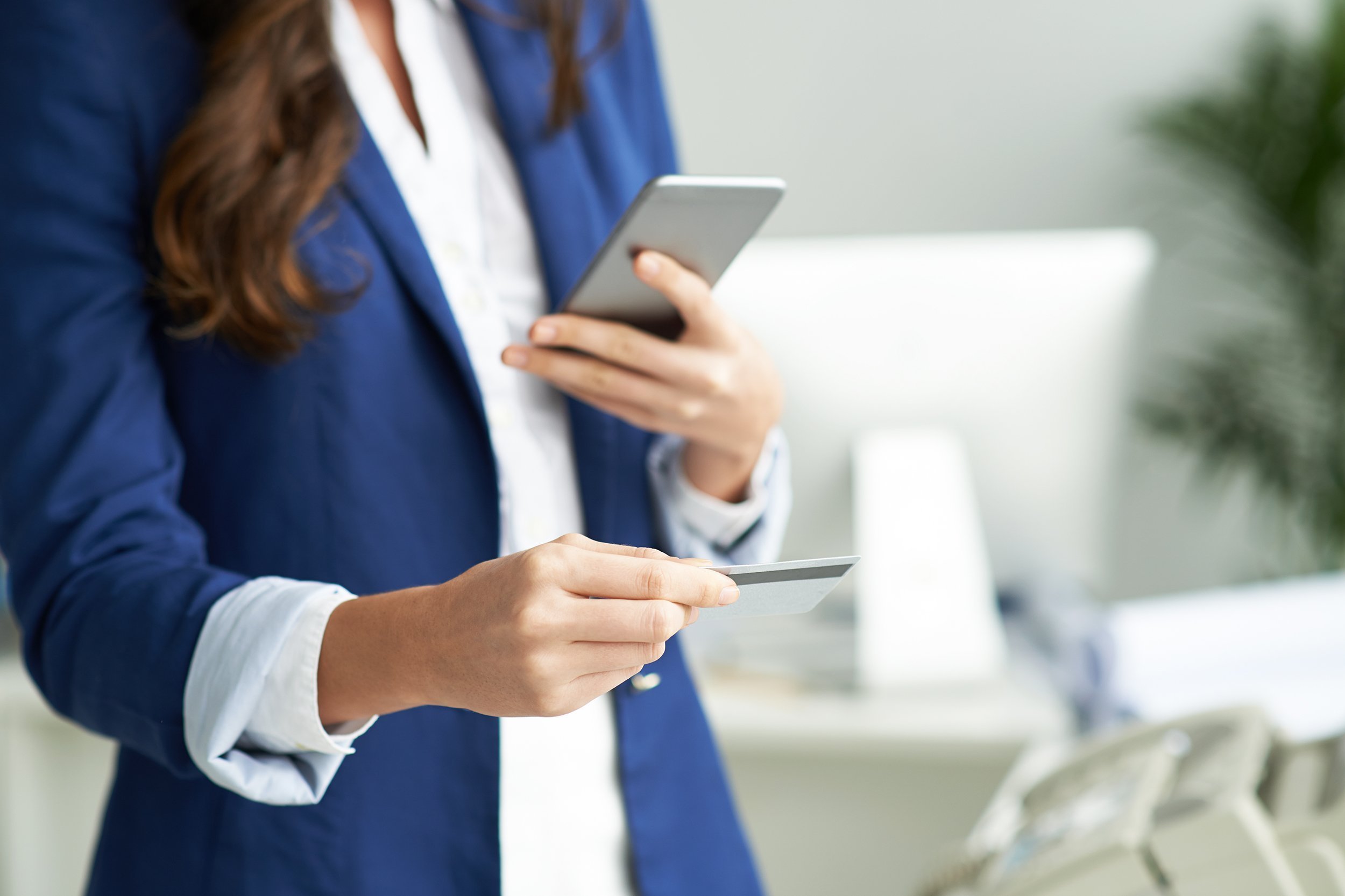 cropped image of business lady using credit card and using phone