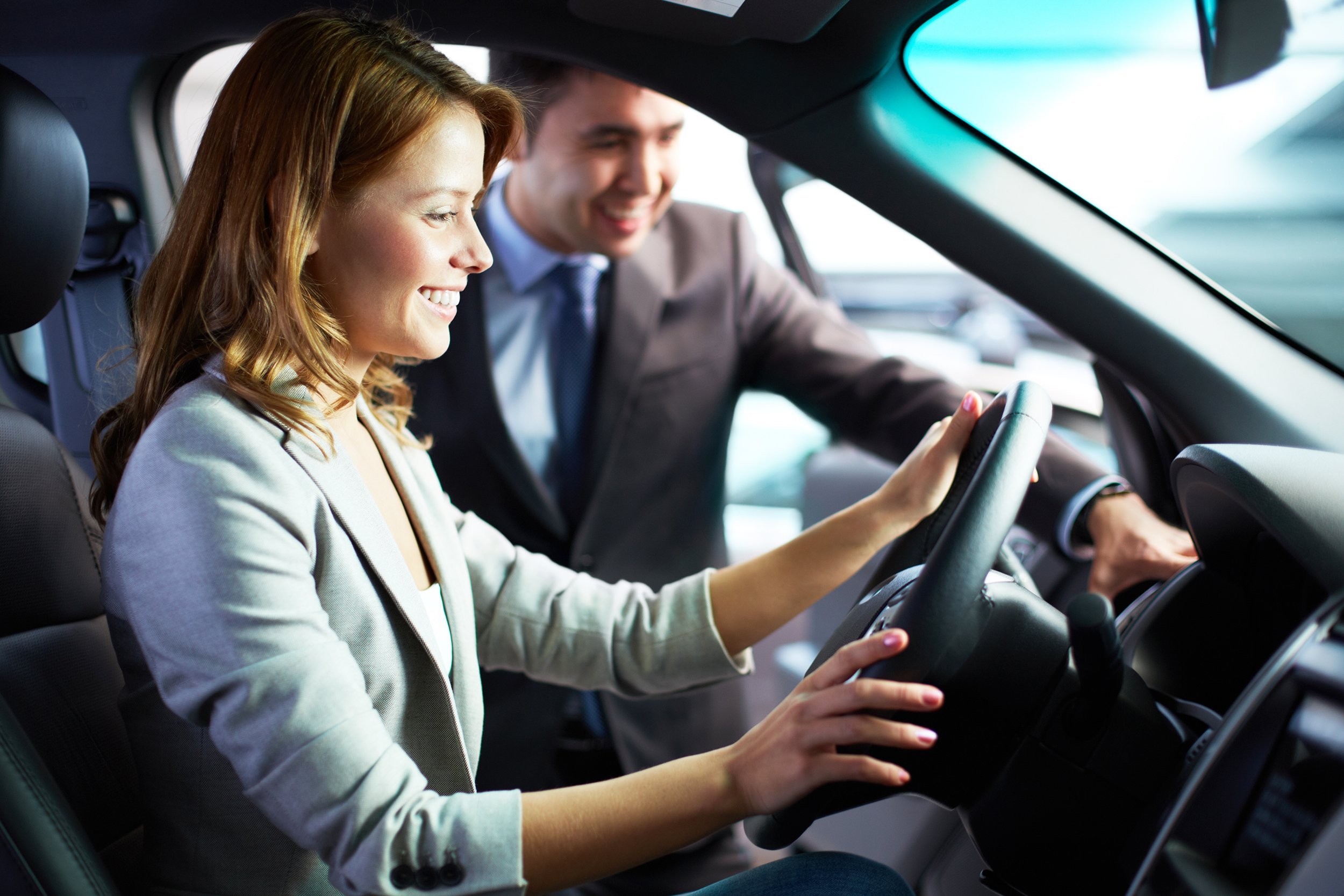 young woman sitting in a car enjoying its comfortable compartment