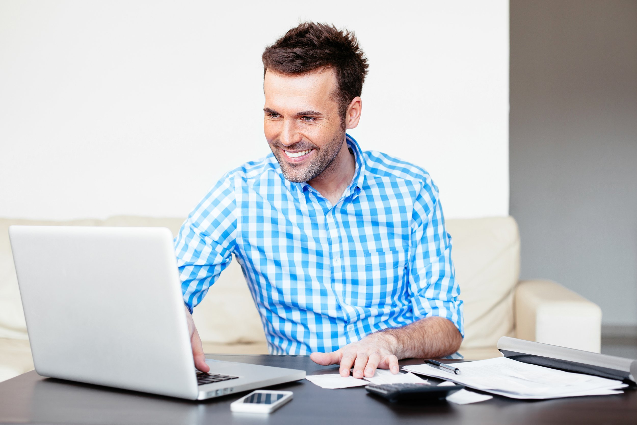 handsome young man paying online using a laptop