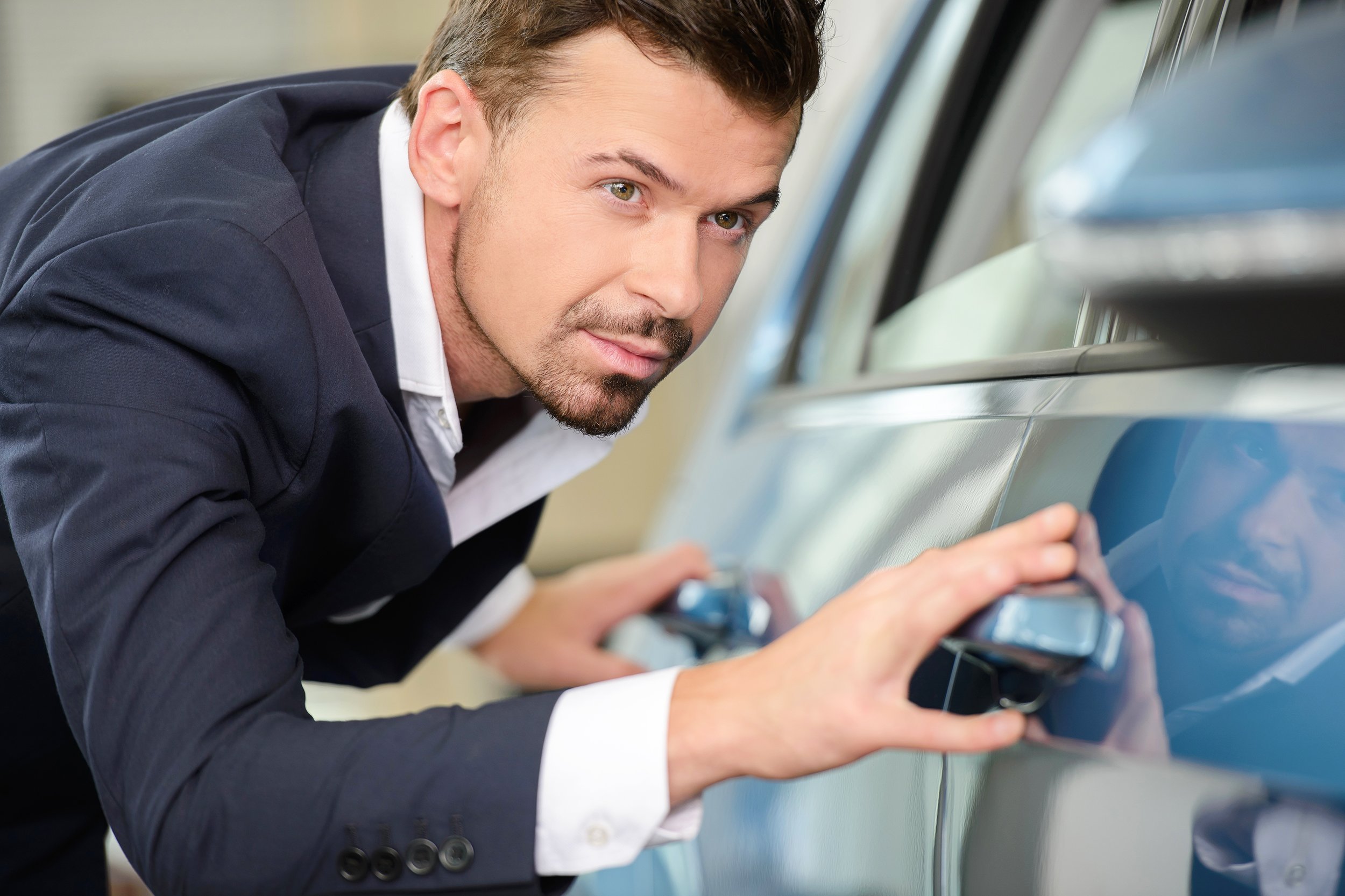 businessman examining a car at the dealership