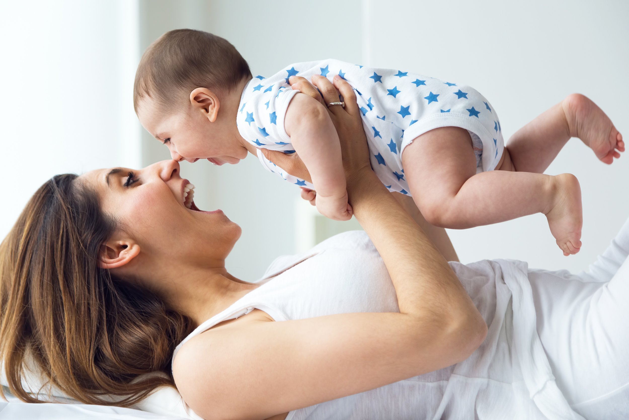 mother and baby playing and smiling at home