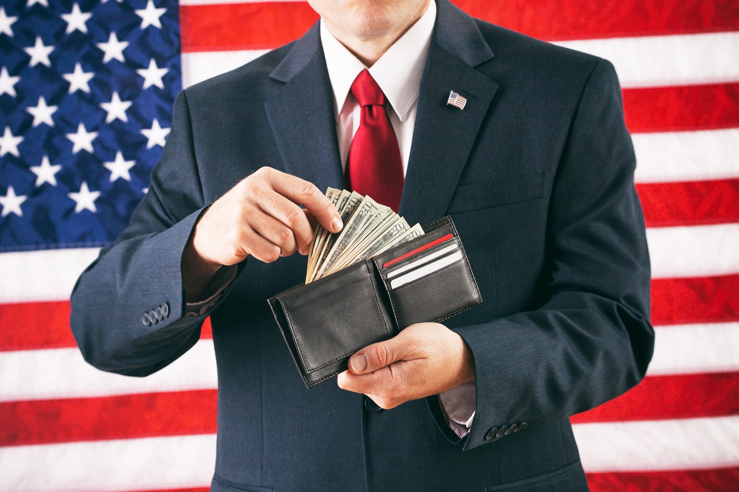 male politician making a withdrawal from cash full wallet