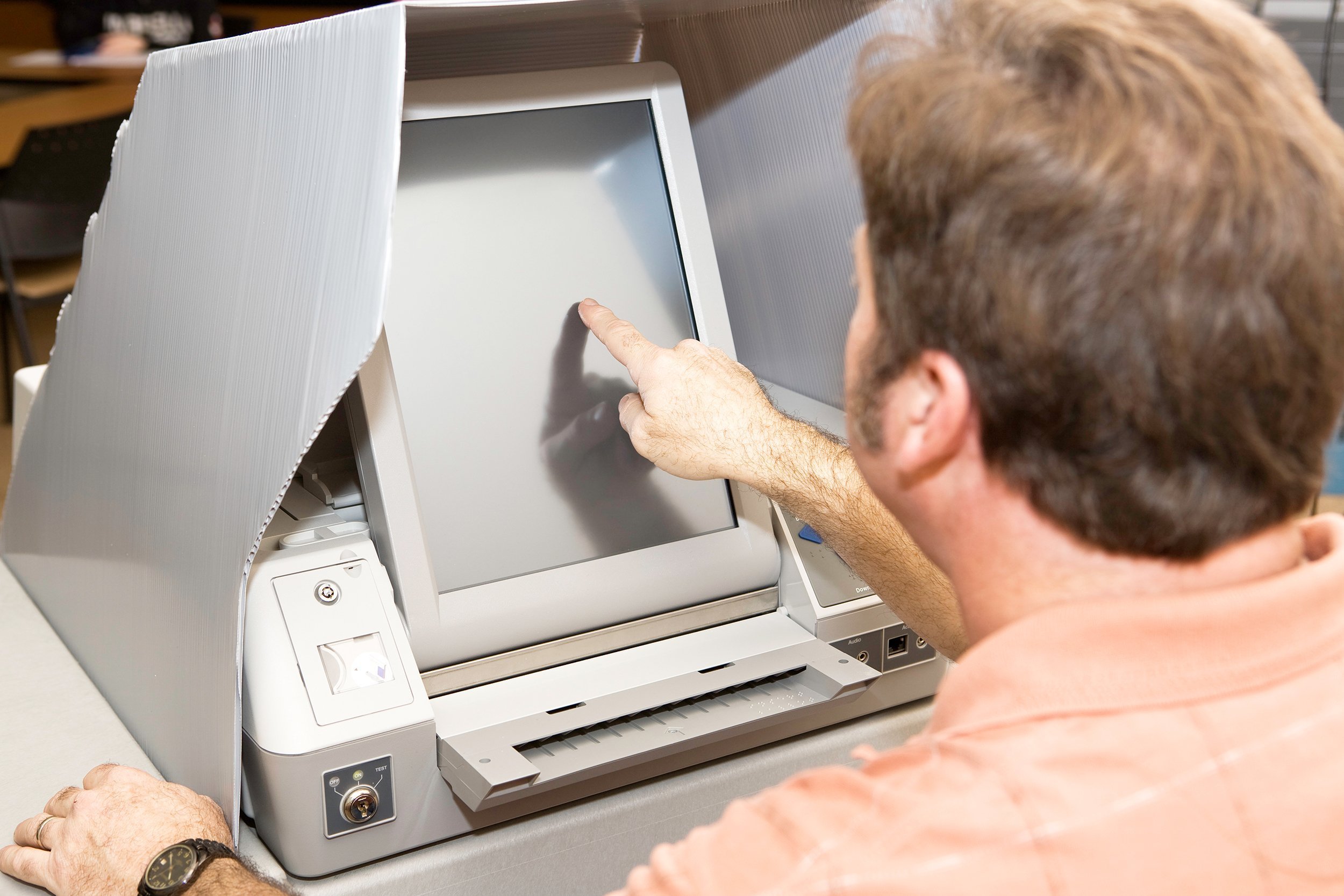 man voting on a new touch screen machine in Florida