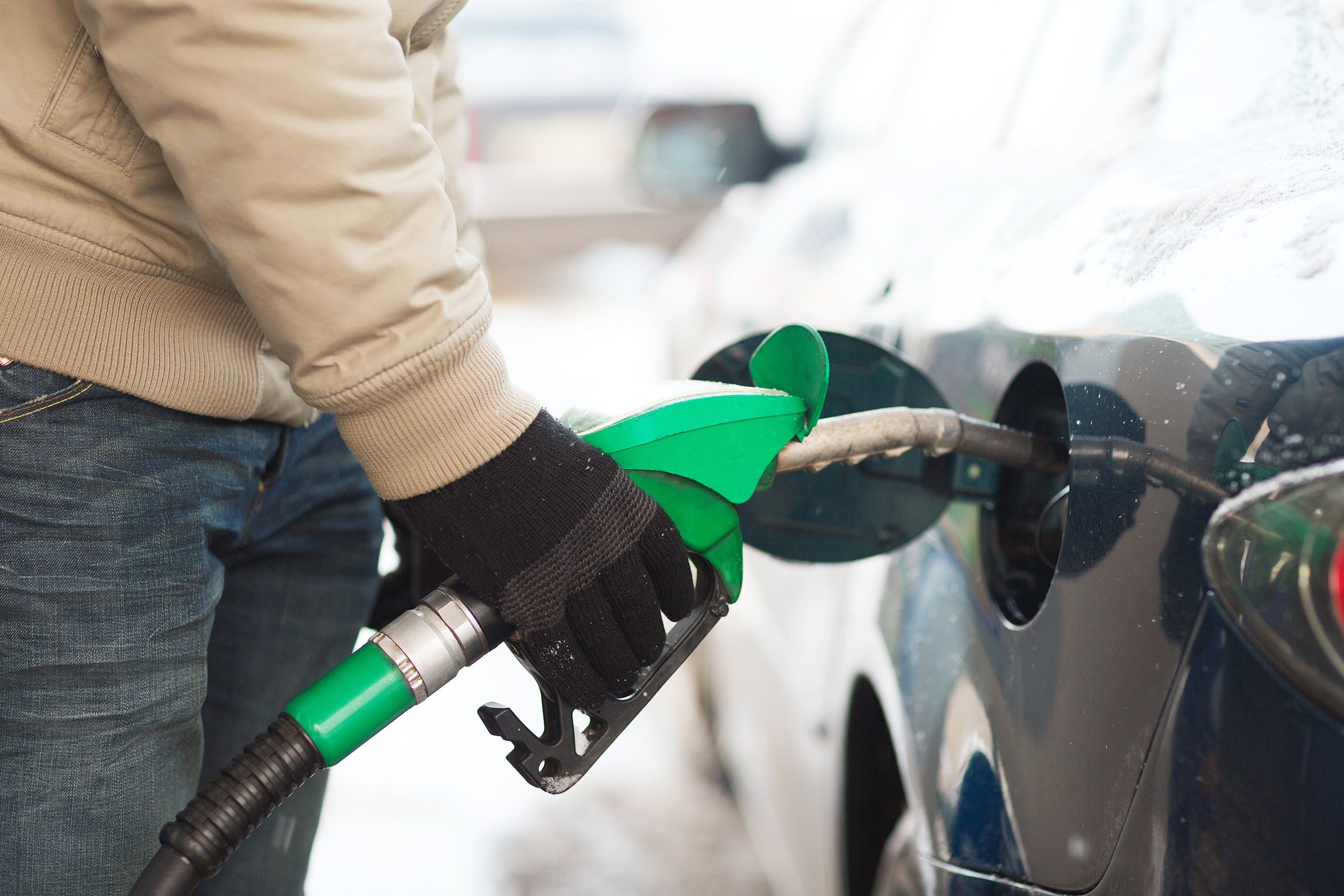 male refilling car fuel tank of car