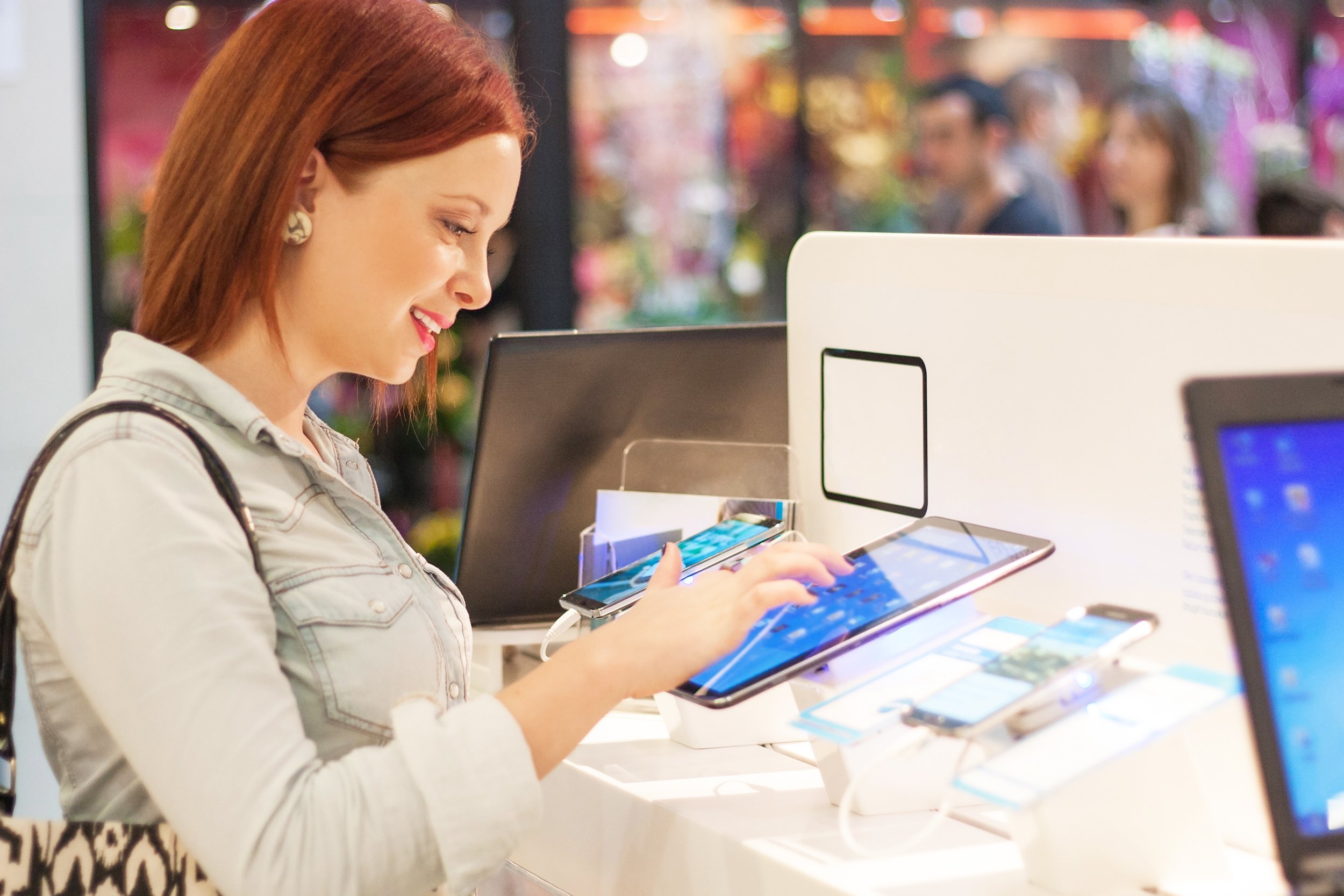 woman in electronics store playing with a digital tablet