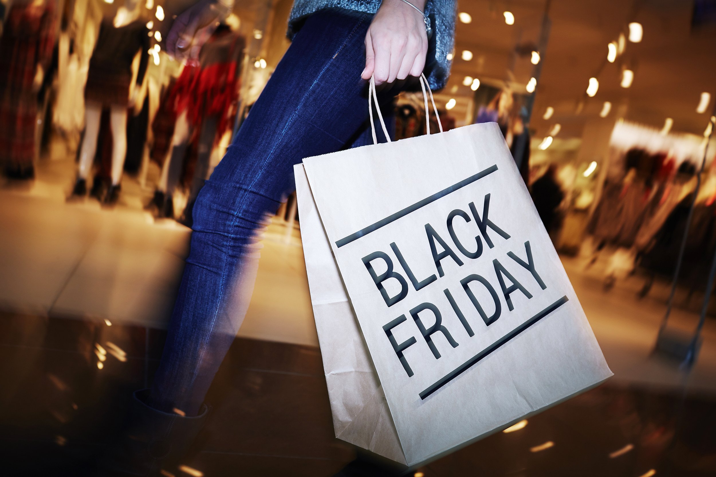 shopper with Black Friday paper bag going in the mall