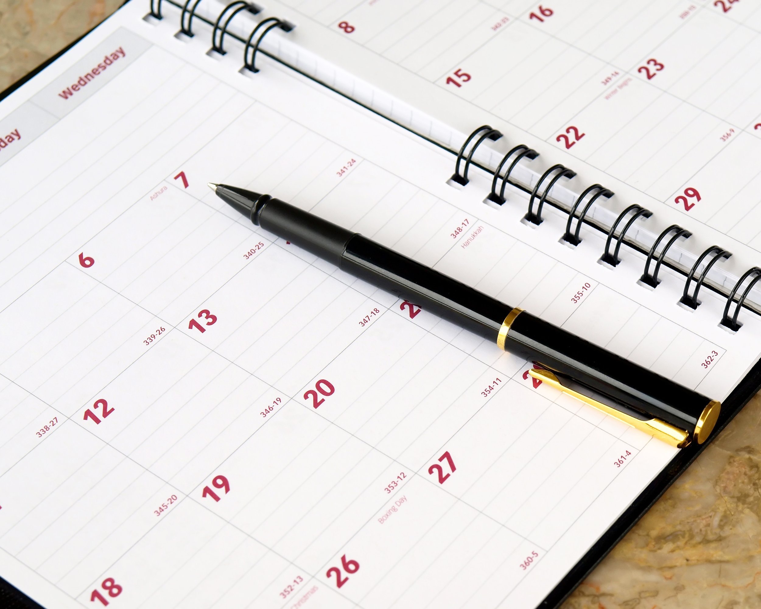 monthly planner with pen on the table