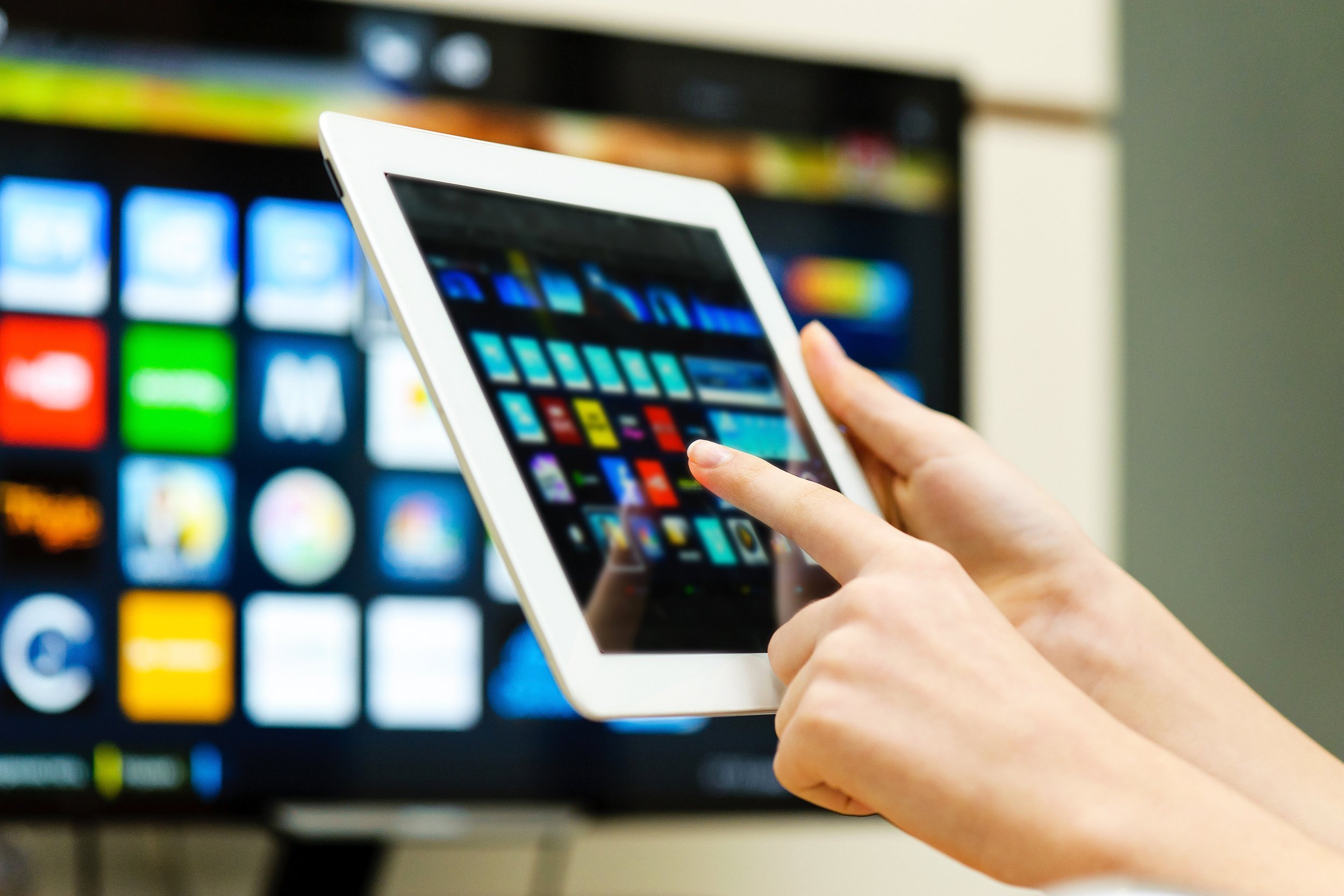 hands holding tablet as remote for tv