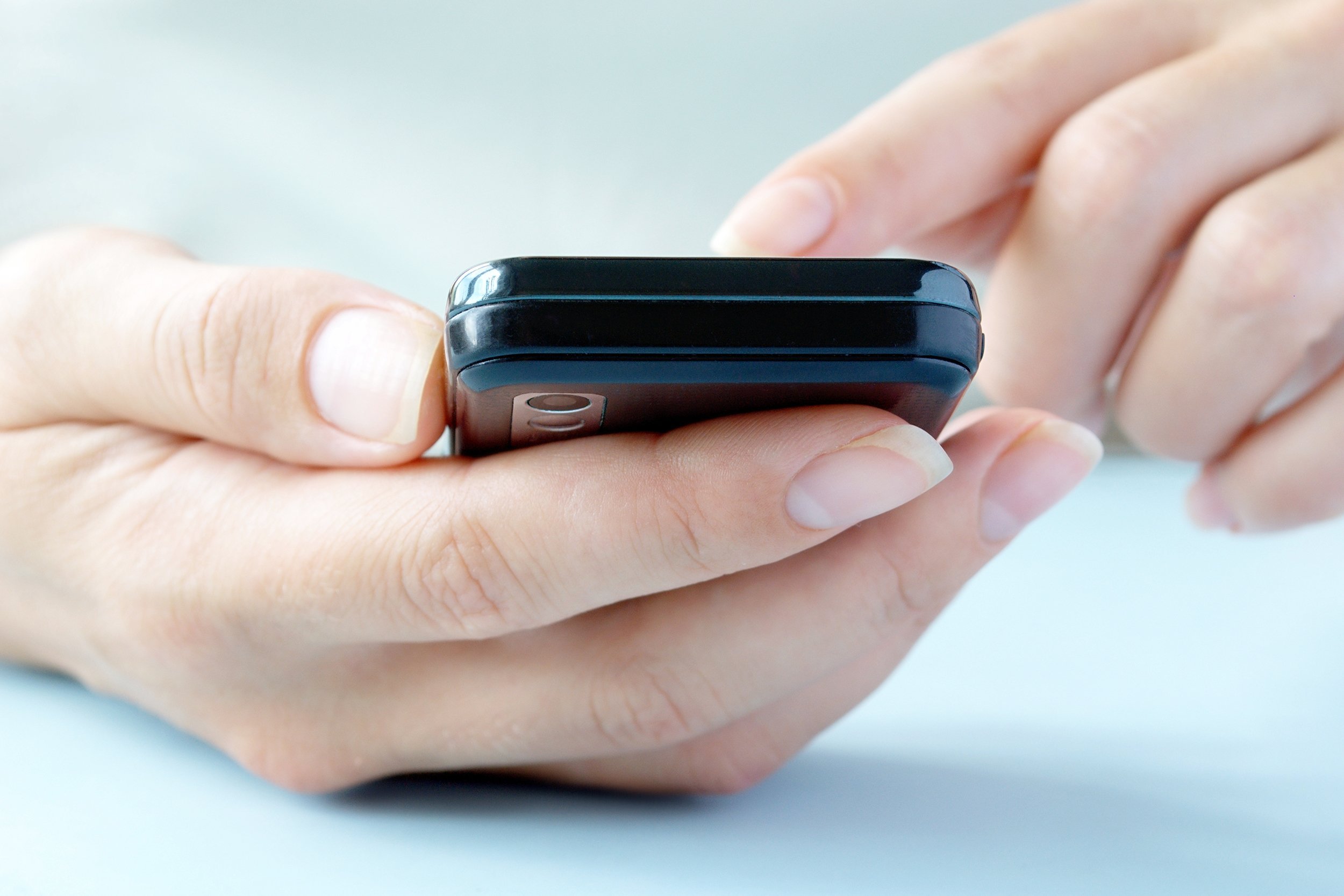touchscreen phone in the hands of a woman