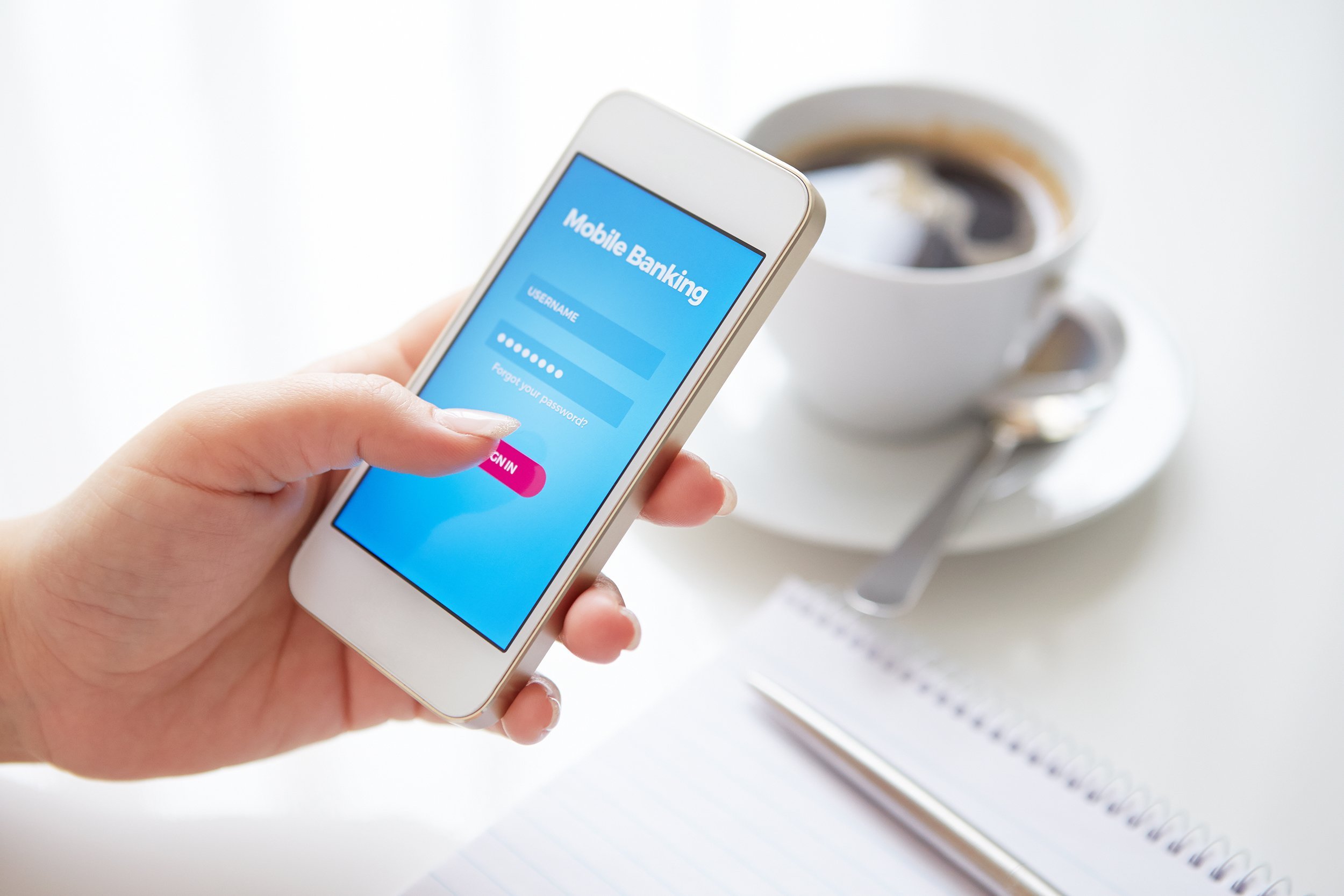 female hand using mobile banking on white smartphone