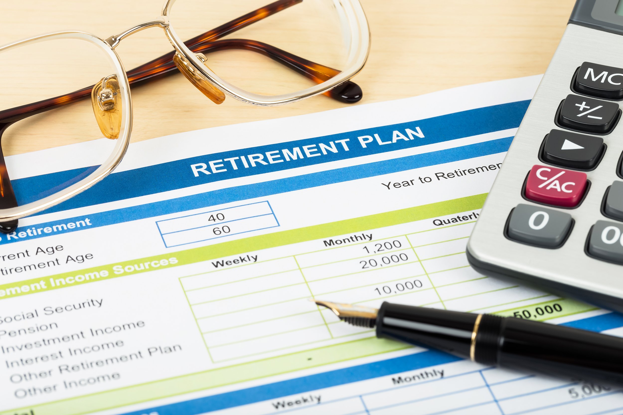 retirement plan with glasses, pen, and calculator