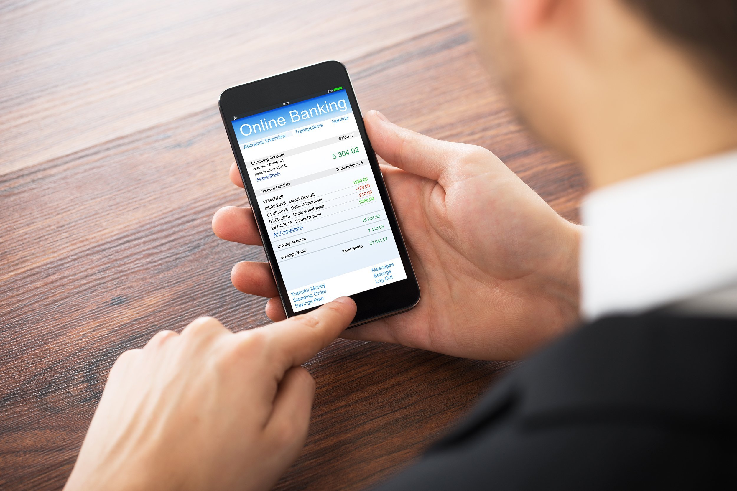 businessman doing online banking on mobile at office desk