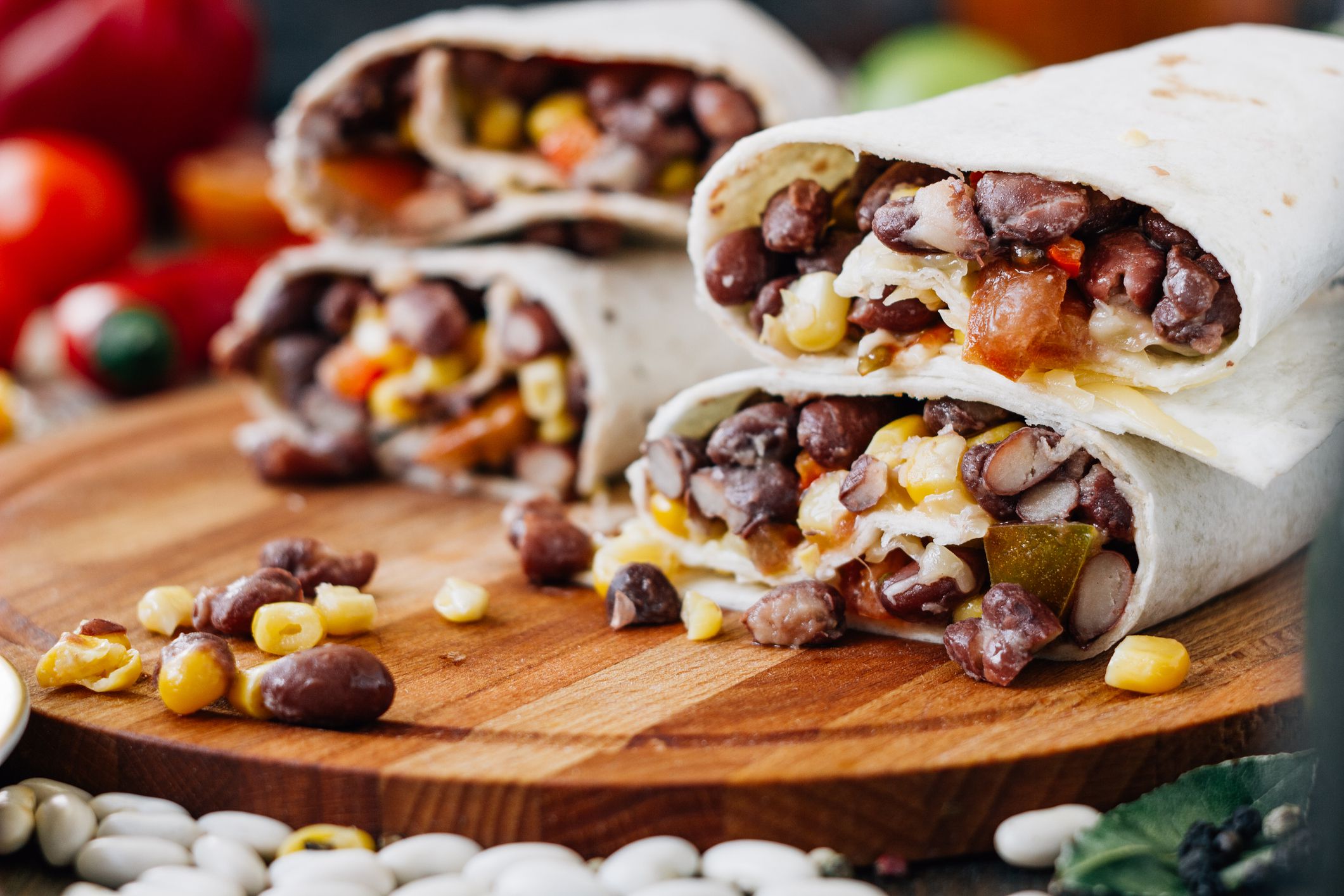 Nice vegetarian burrito over black table on wooden board