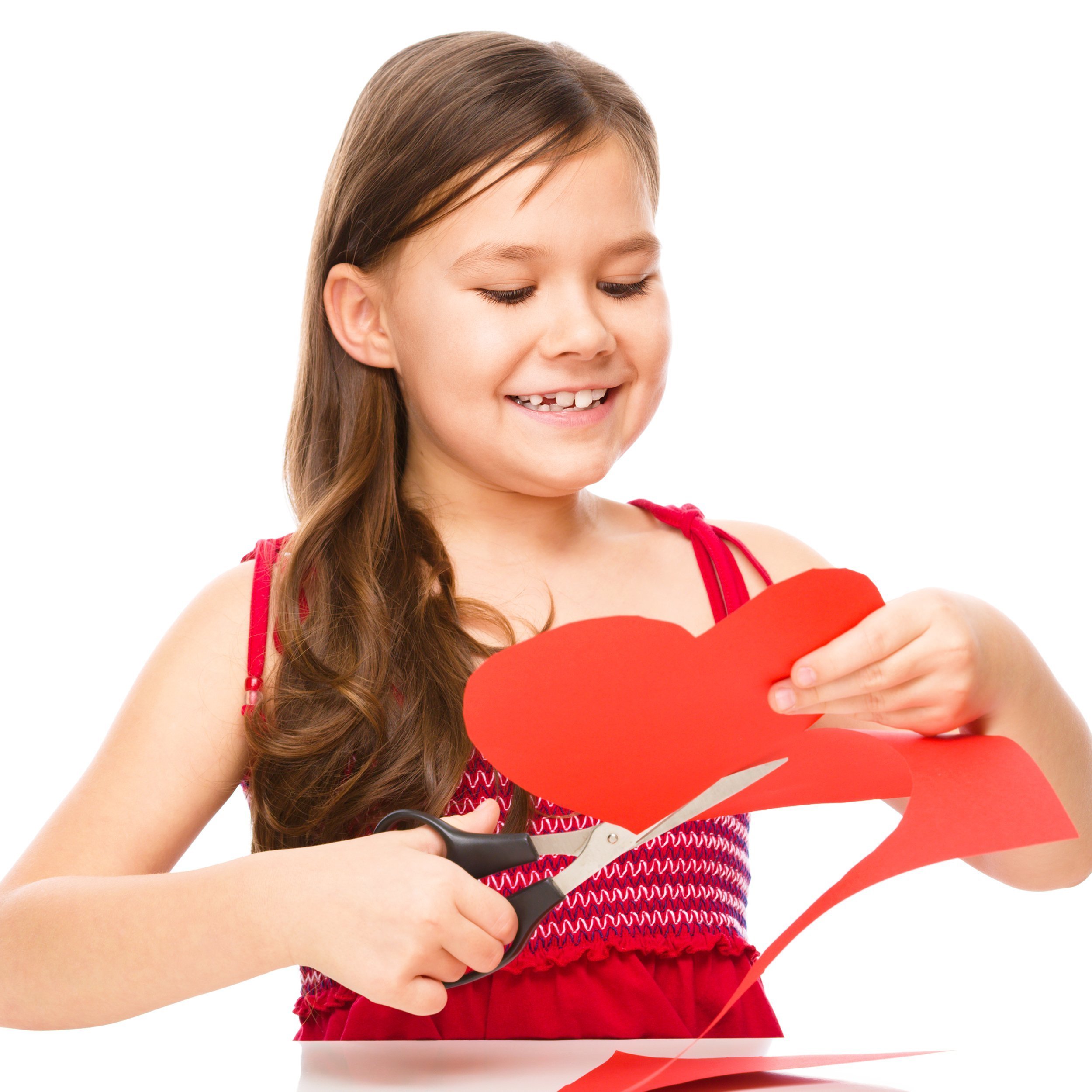 girl cutting out red heart