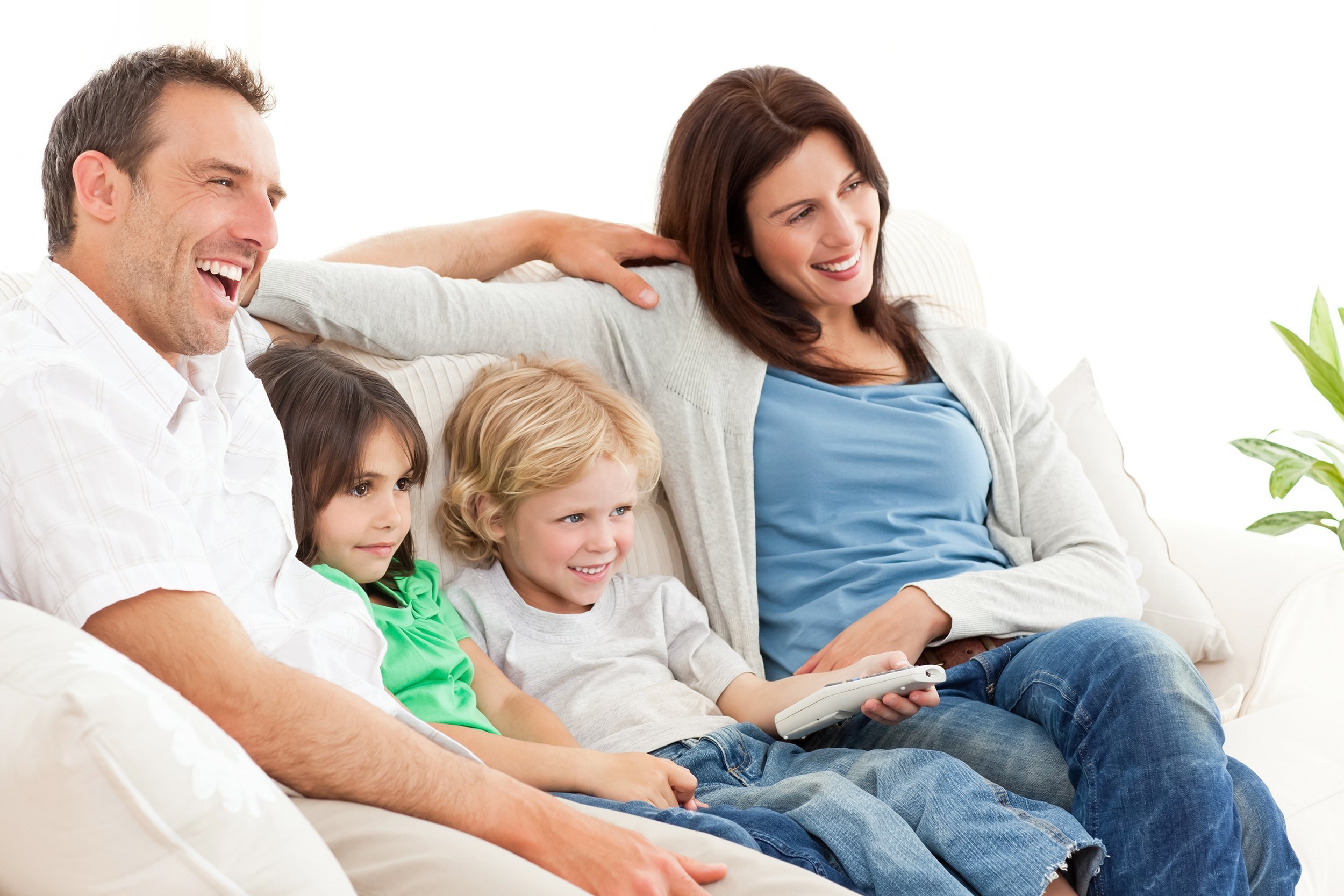 happy family watching television together on the sofa
