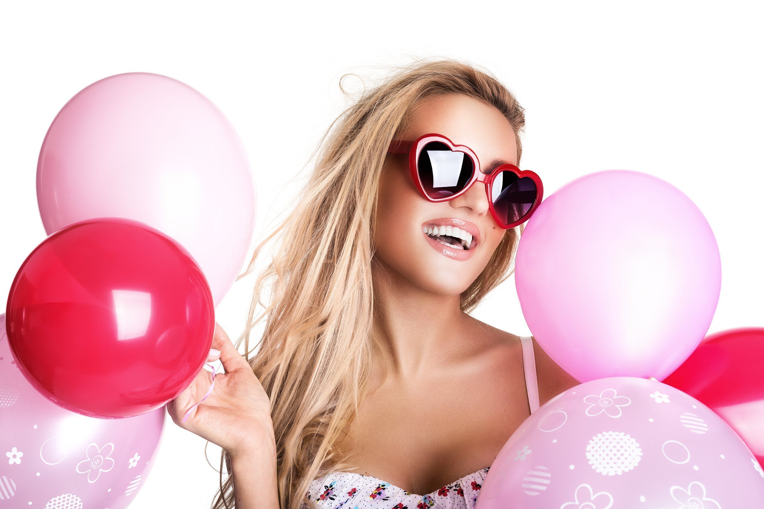 woman with glasses holding pink balloons