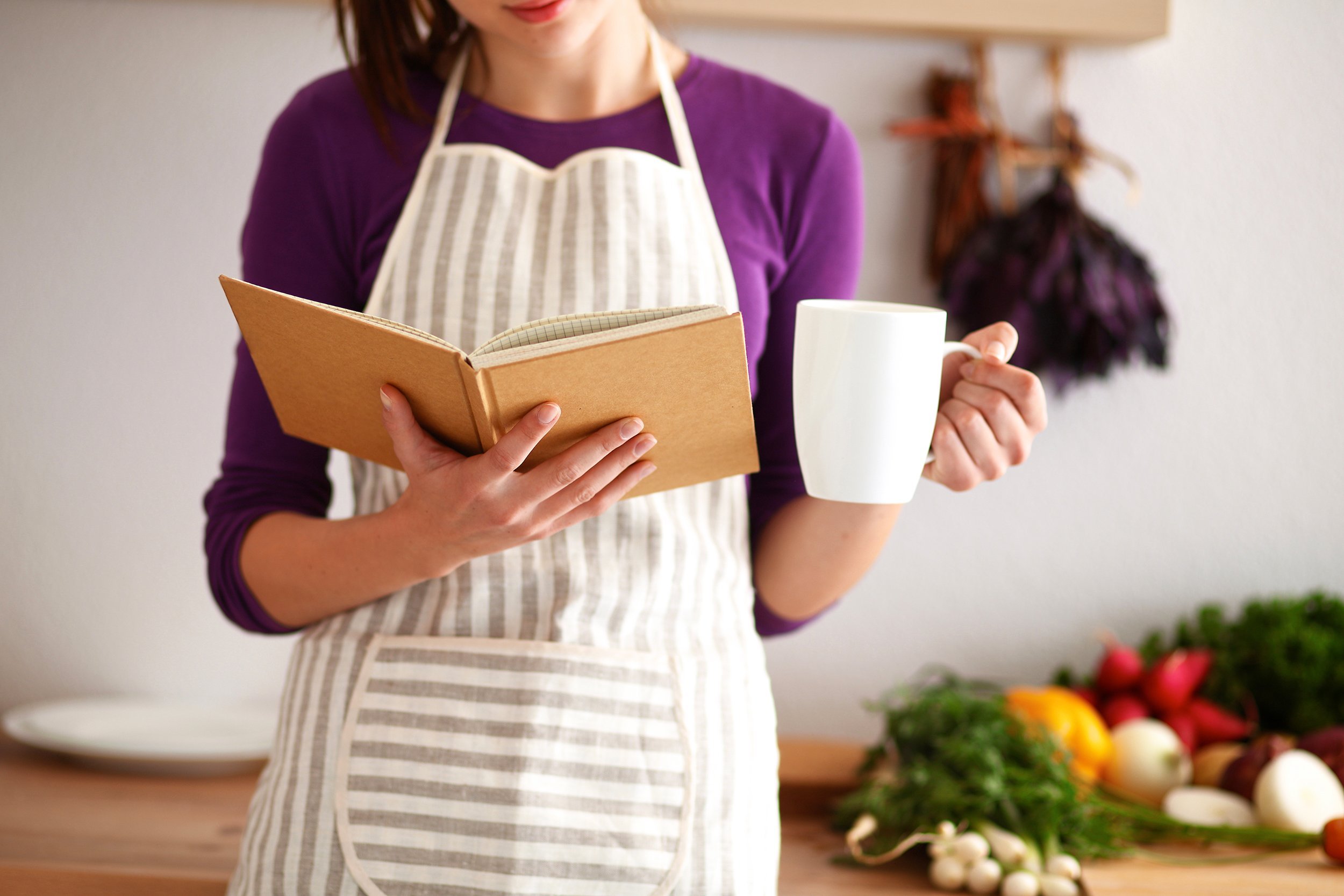 woman reading cookbook in the kitchen