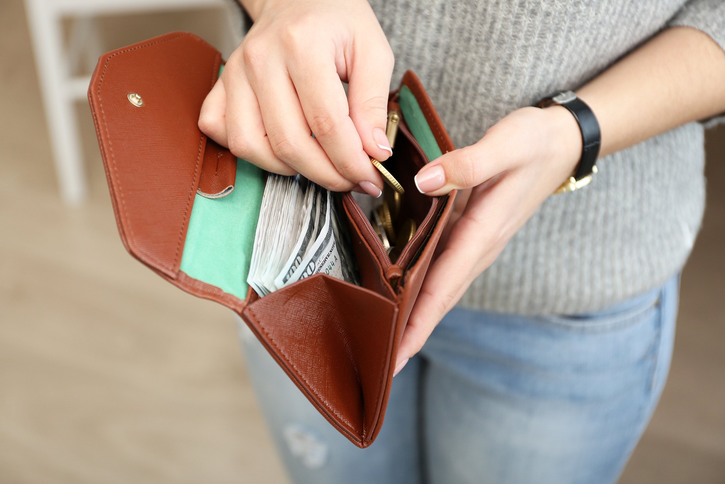 woman with brown wallet full of money