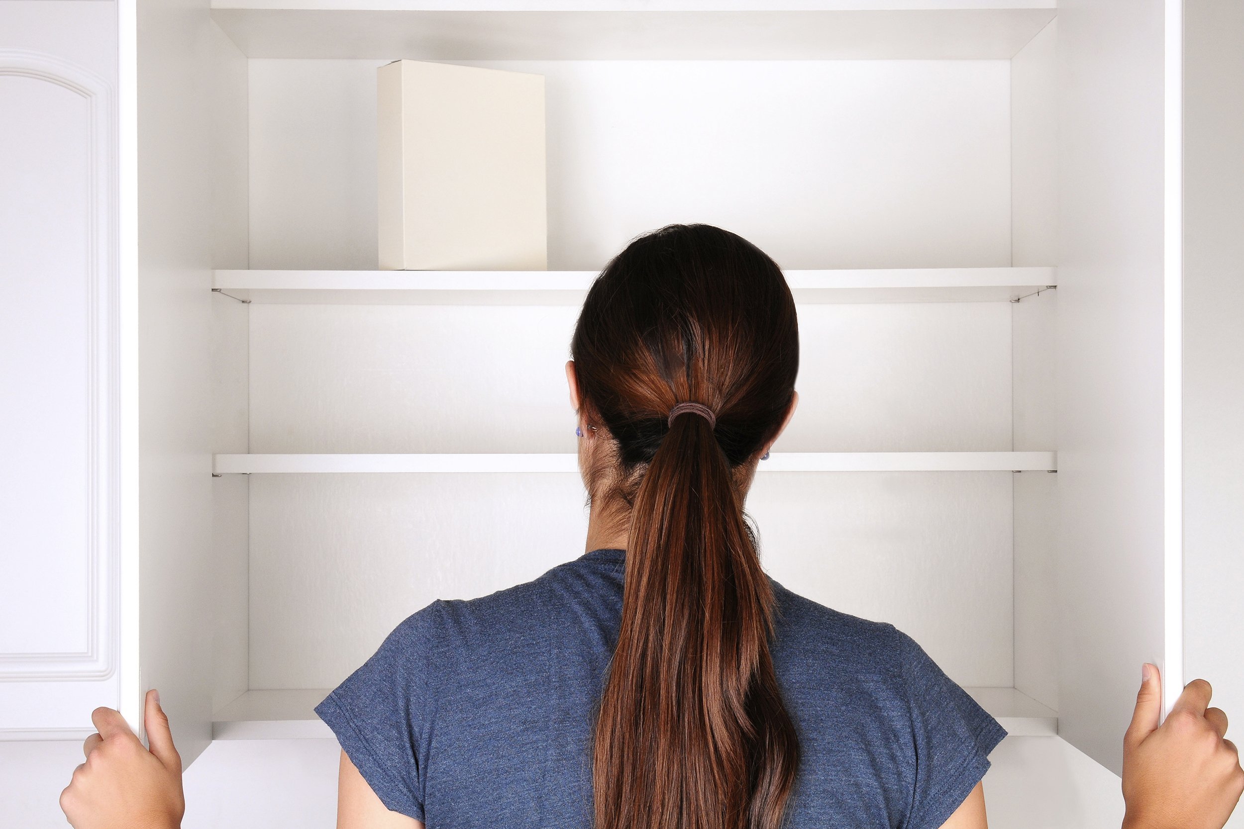closeup of a woman looking in an empty pantry