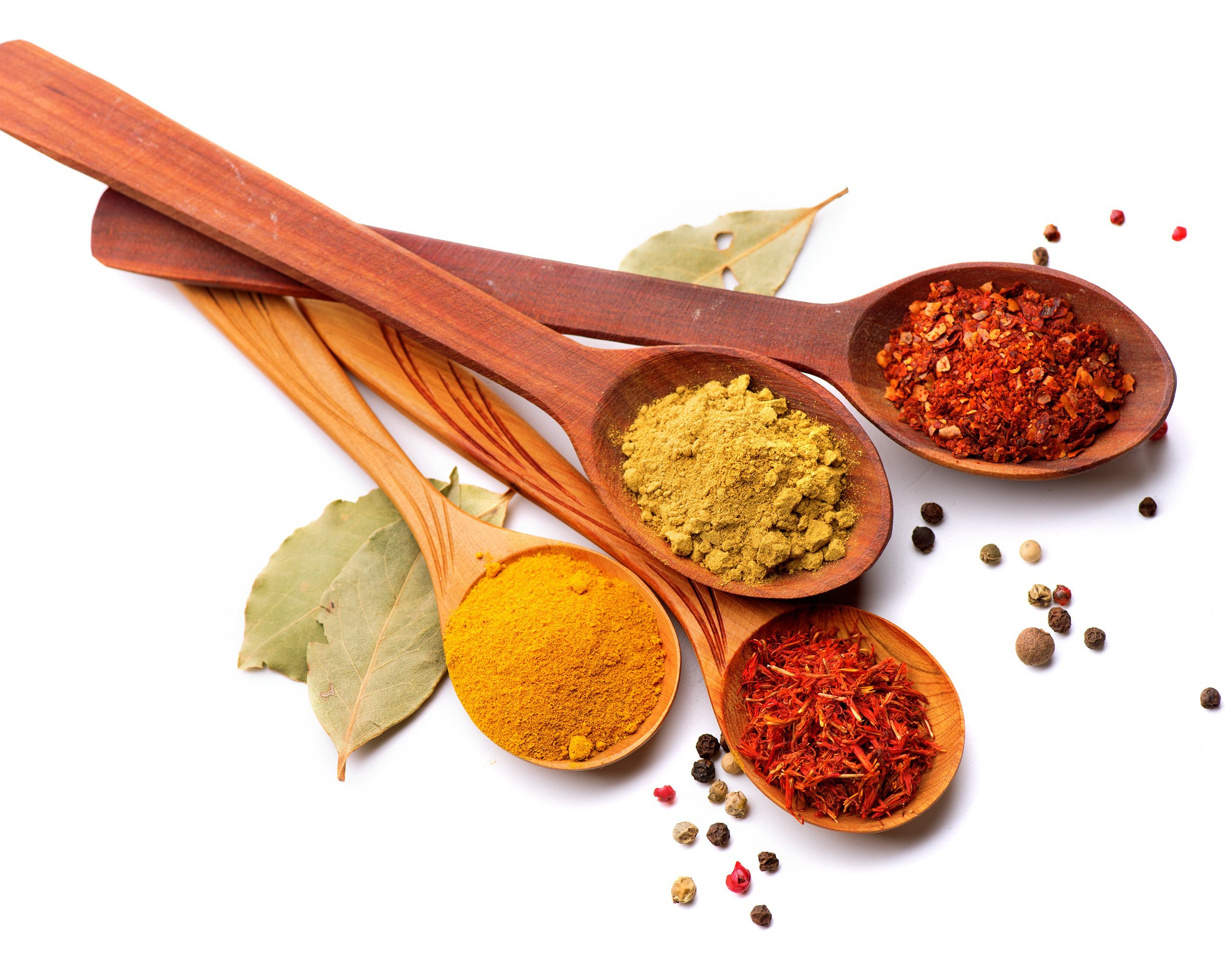 four spices on wooden spoons