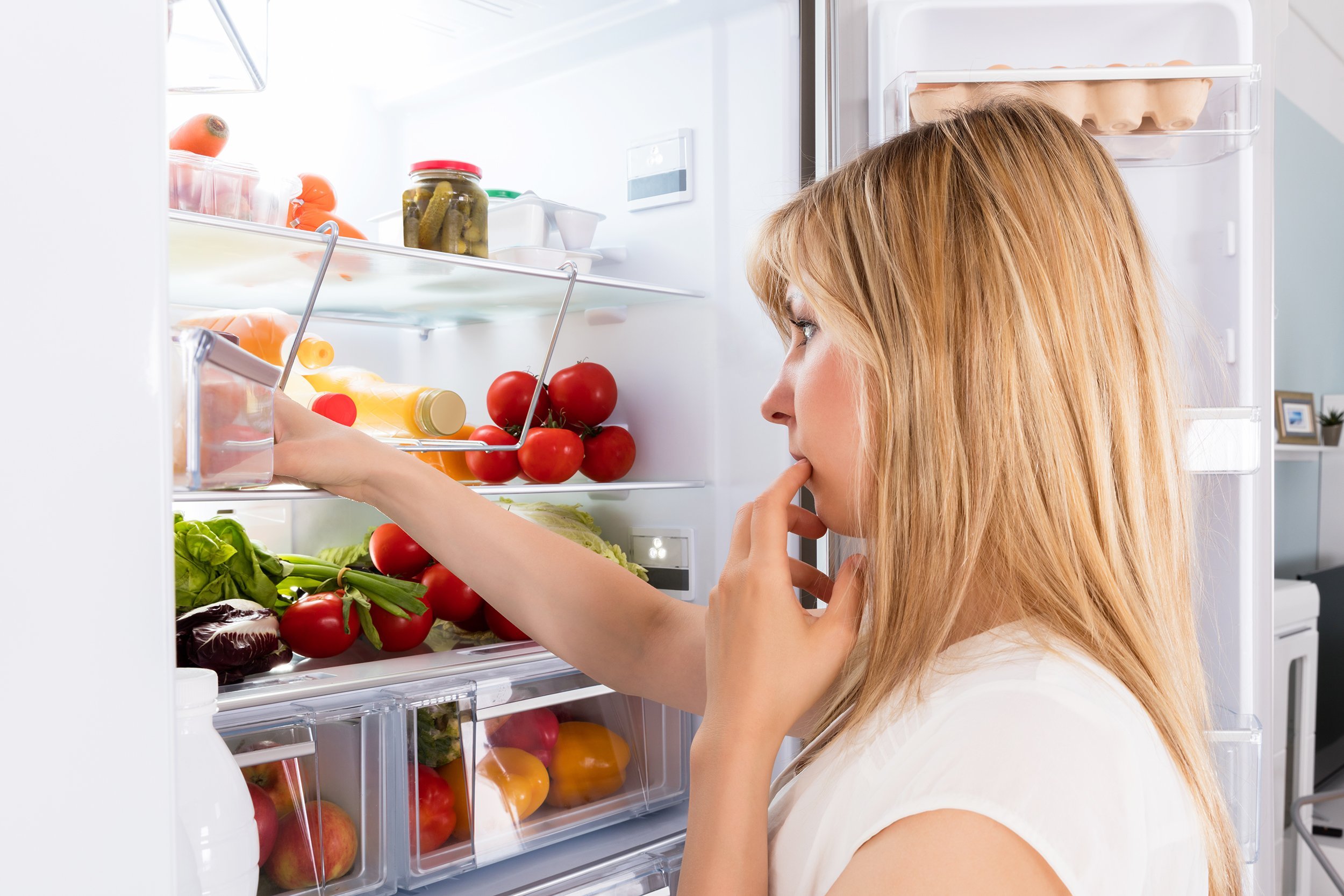 woman looking in fridge at kitchen