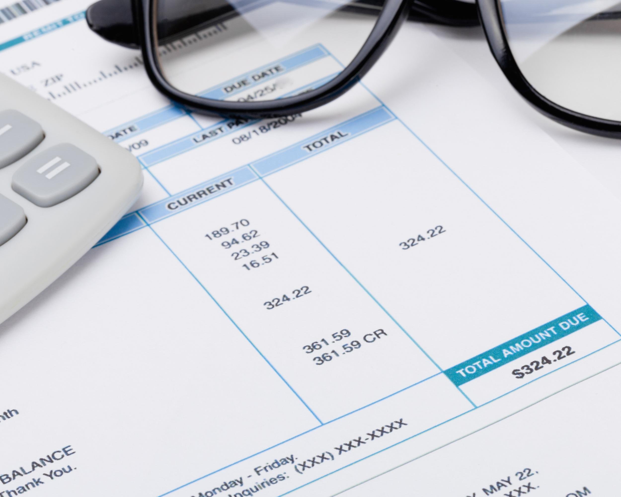 calculator and glasses over receipt