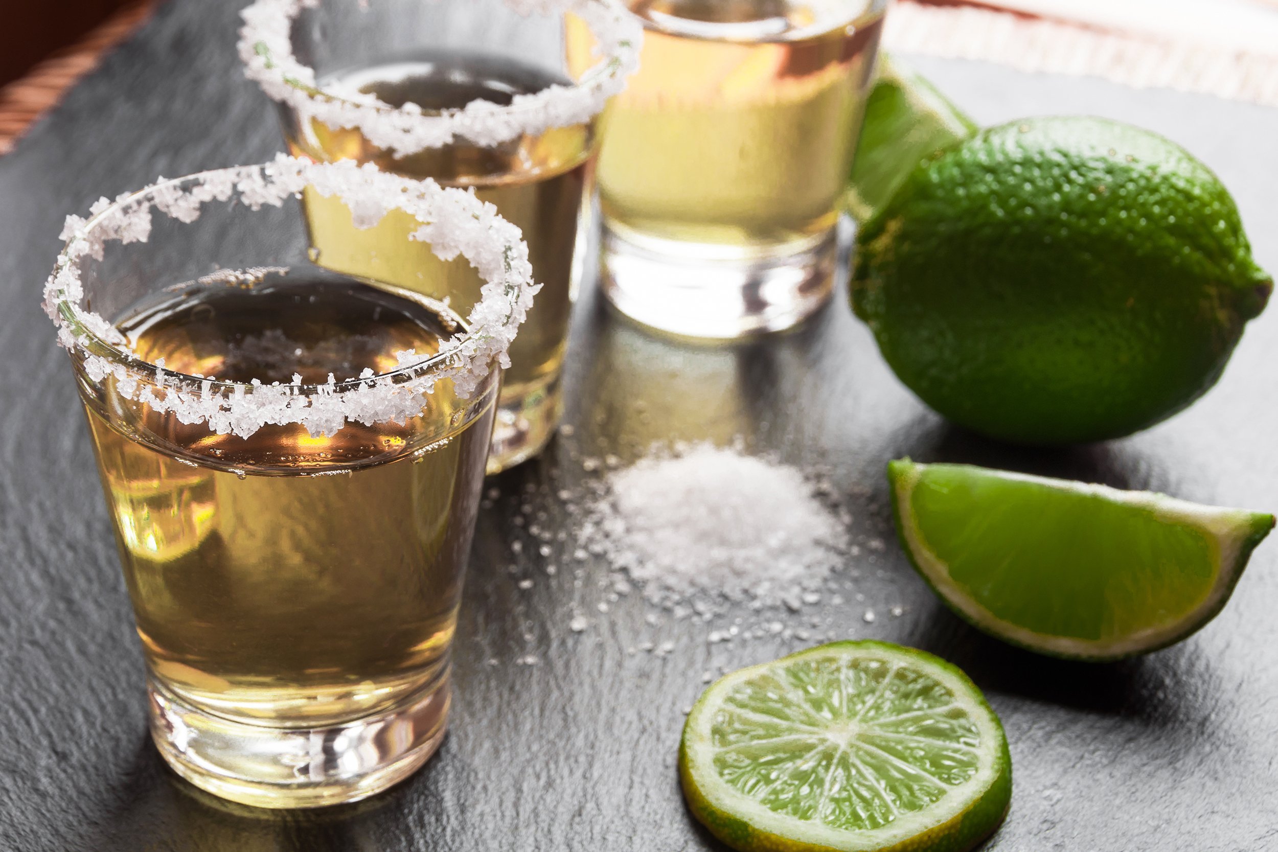 tequila shots with lime and salt on black