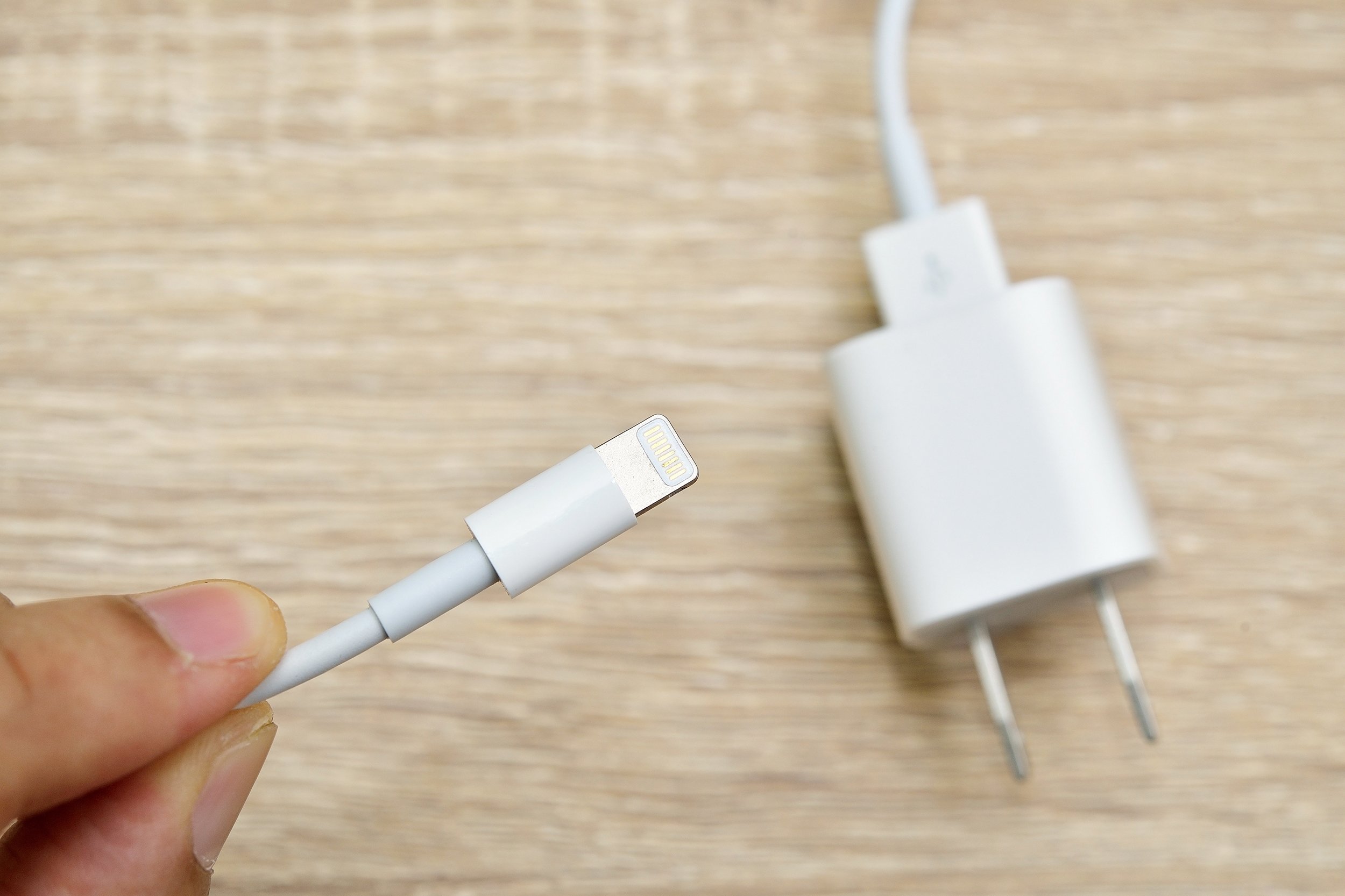 iPhone charger in hand