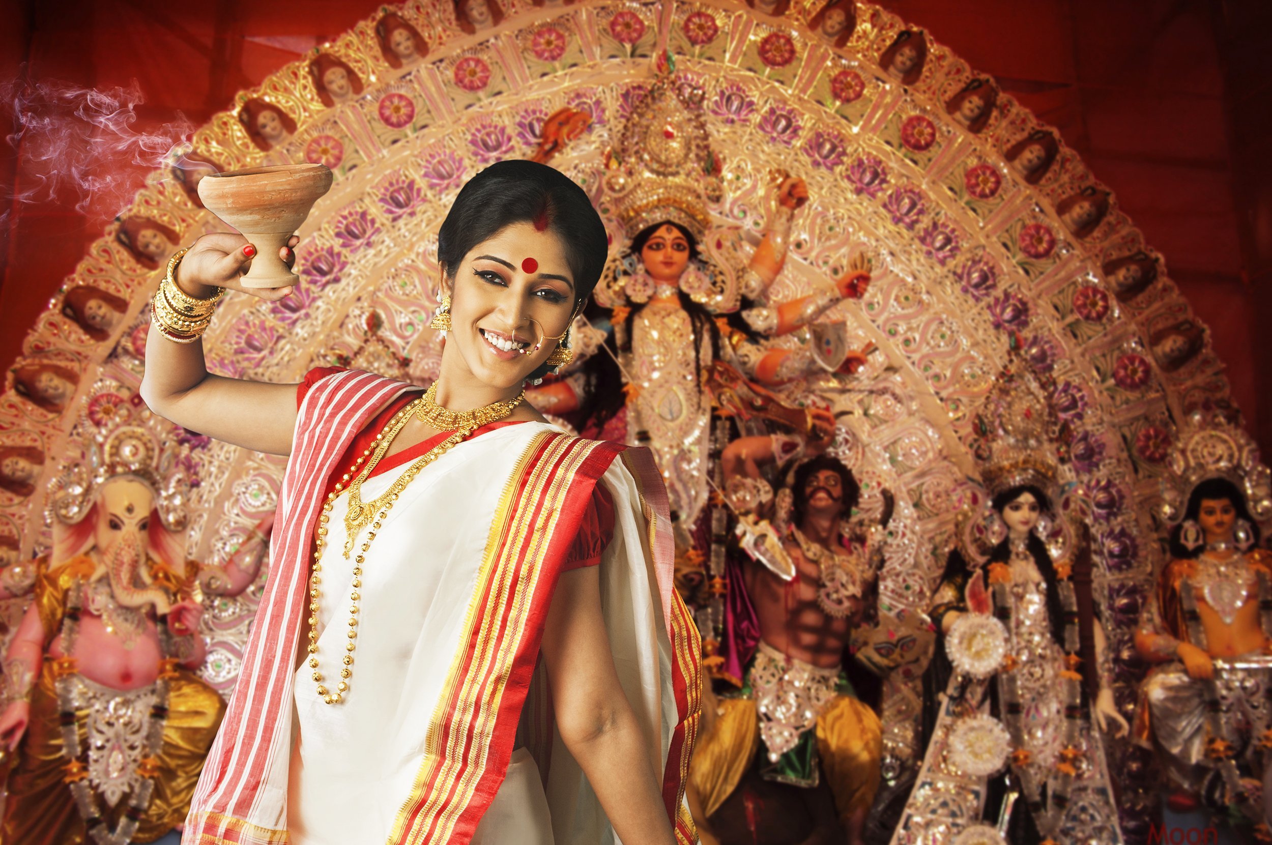 Bengali woman holding a dhunuchi during Durga Puja
