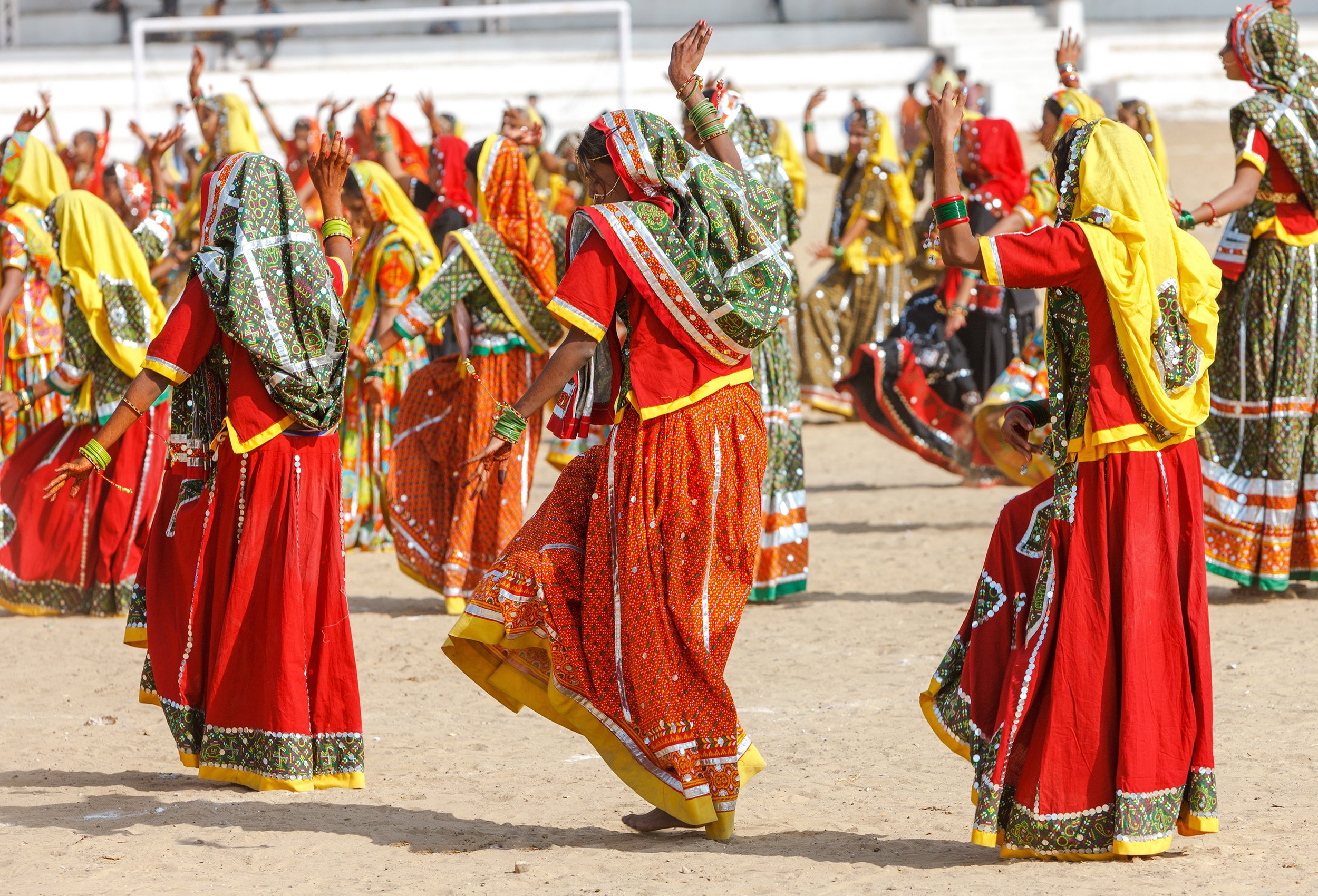 Indian girls in colorful ethnic attire dancing in Pushkar celebration