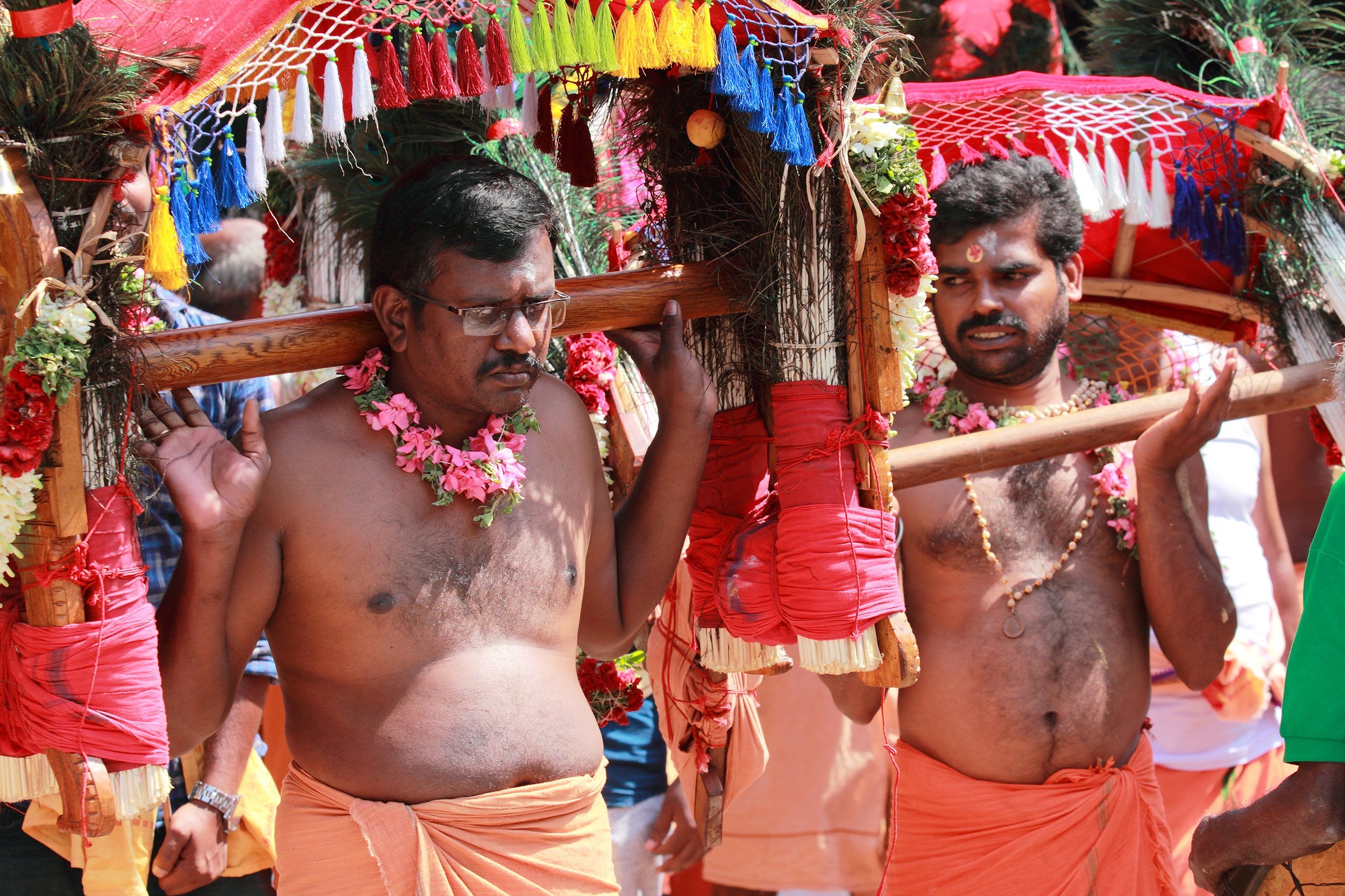devotees hold a decorated arch and participates in the Thaipusam festival at the Murugan temple